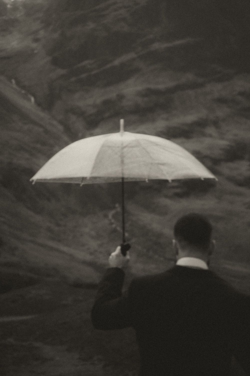 A sequence of black and white photographs showing a white umbrella against a dark stormy sky in various positions.