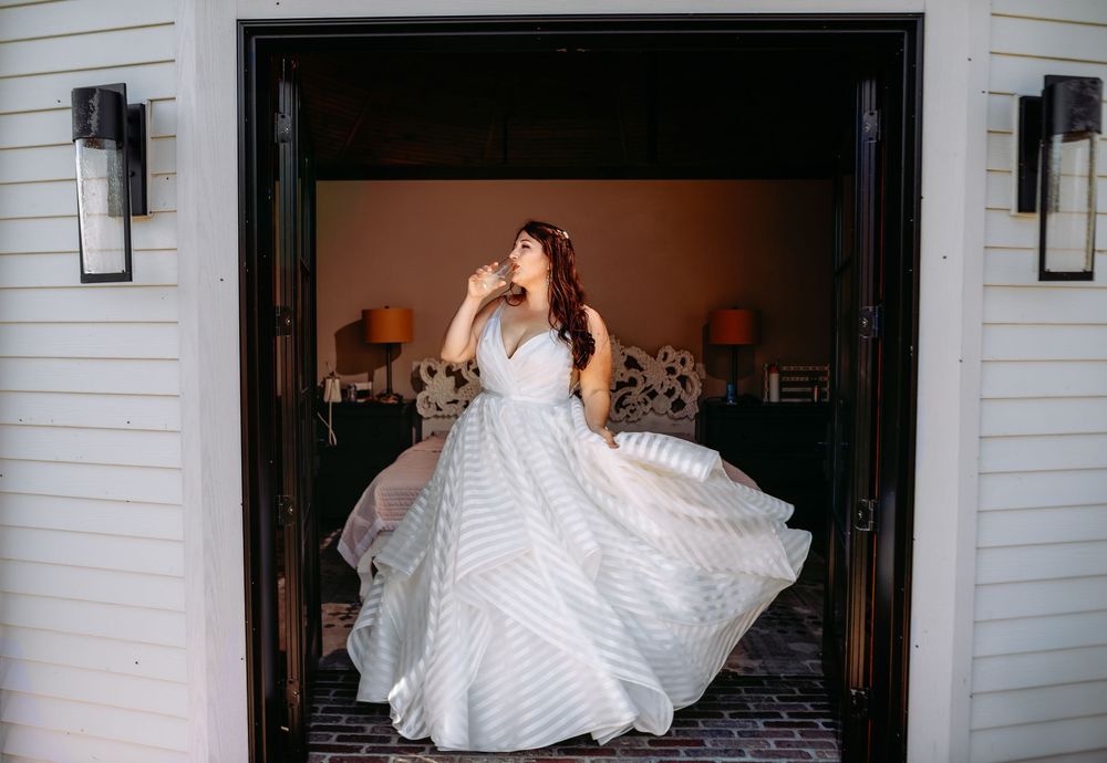 A series of four black and white photos showing a bride twirling in her wedding dress indoors.