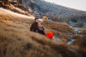 Couple enjoys romantic moment on hillside during golden hour.
