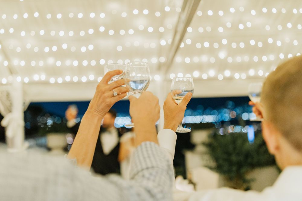 Rows of glowing string lights create a magical canopy over an outdoor evening celebration.