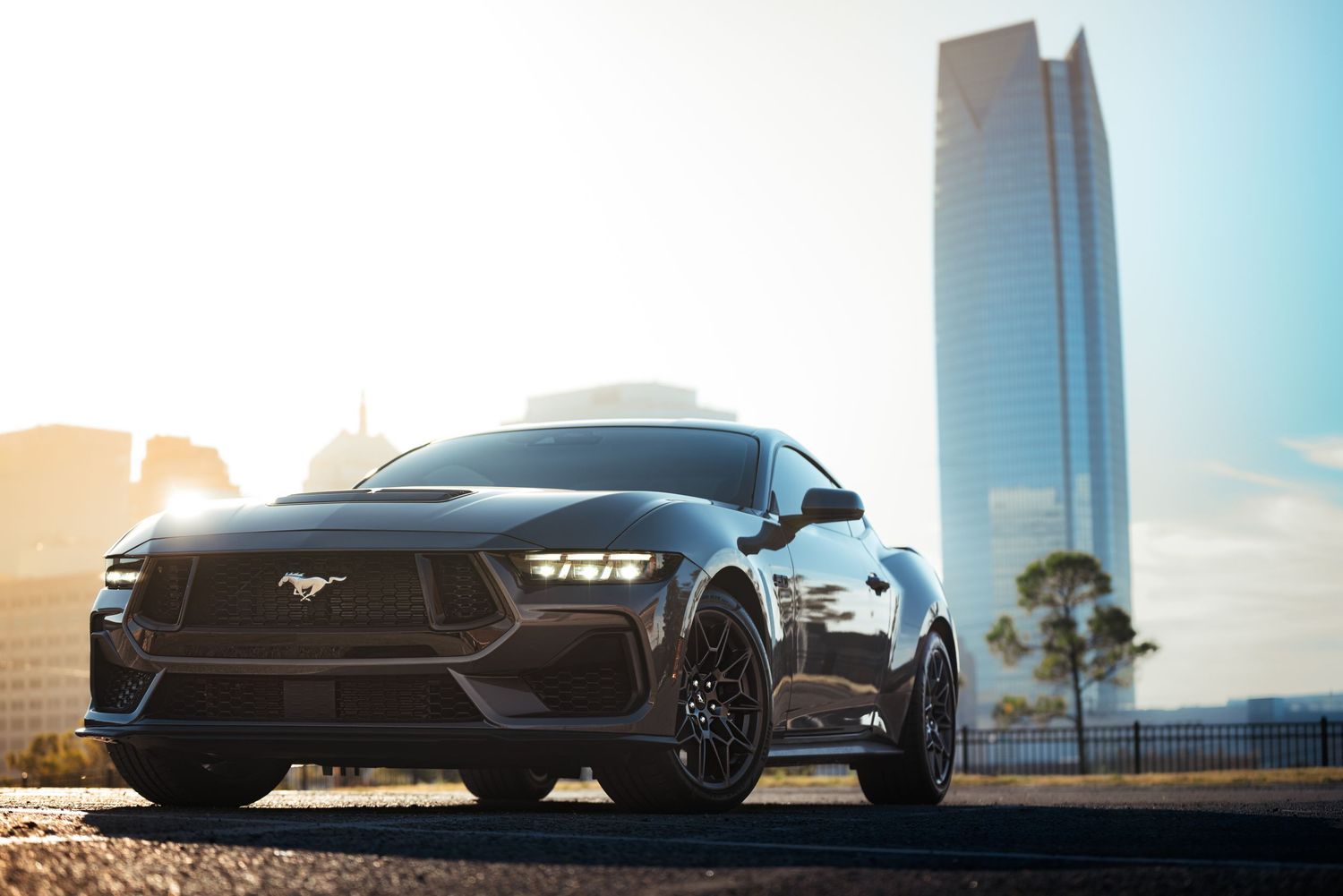 Sleek black sports car with futuristic design features shown from multiple angles against urban and desert backgrounds.