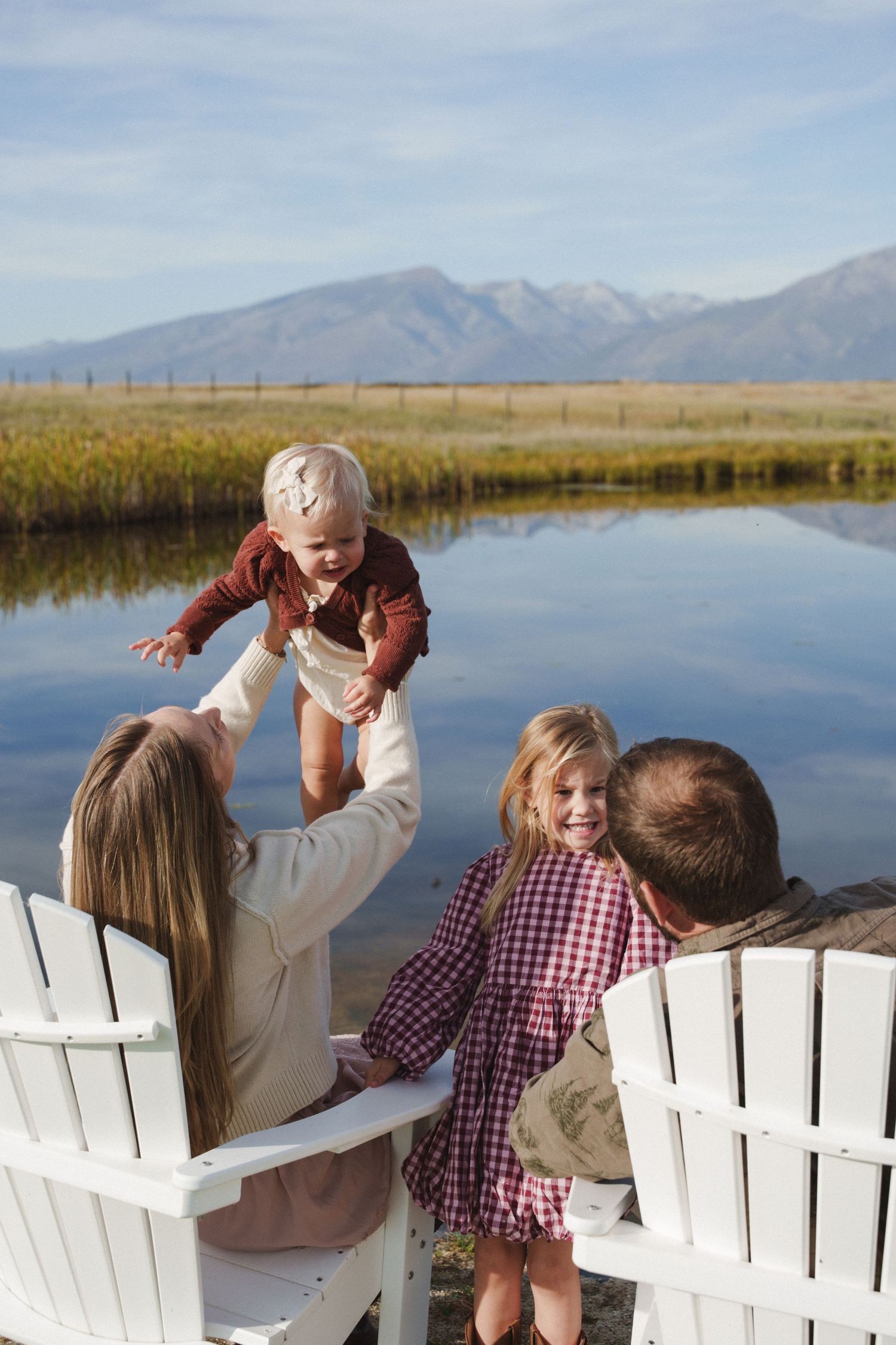People gather on a covered porch at sunset overlooking a fenced pasture with golden sunlight streaming through.