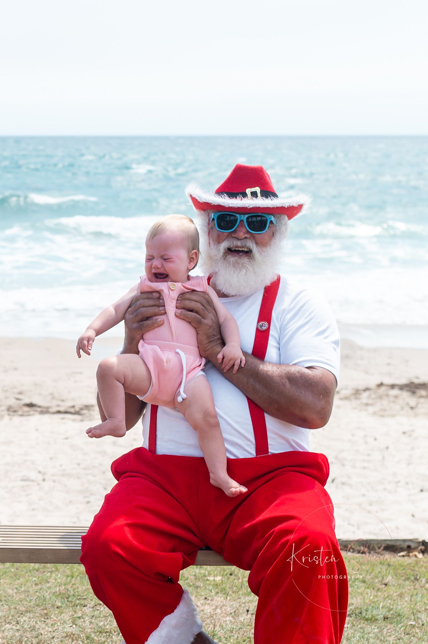 Heartwarming beach scene with traditional holiday characters enjoying a sunny day by the ocean.