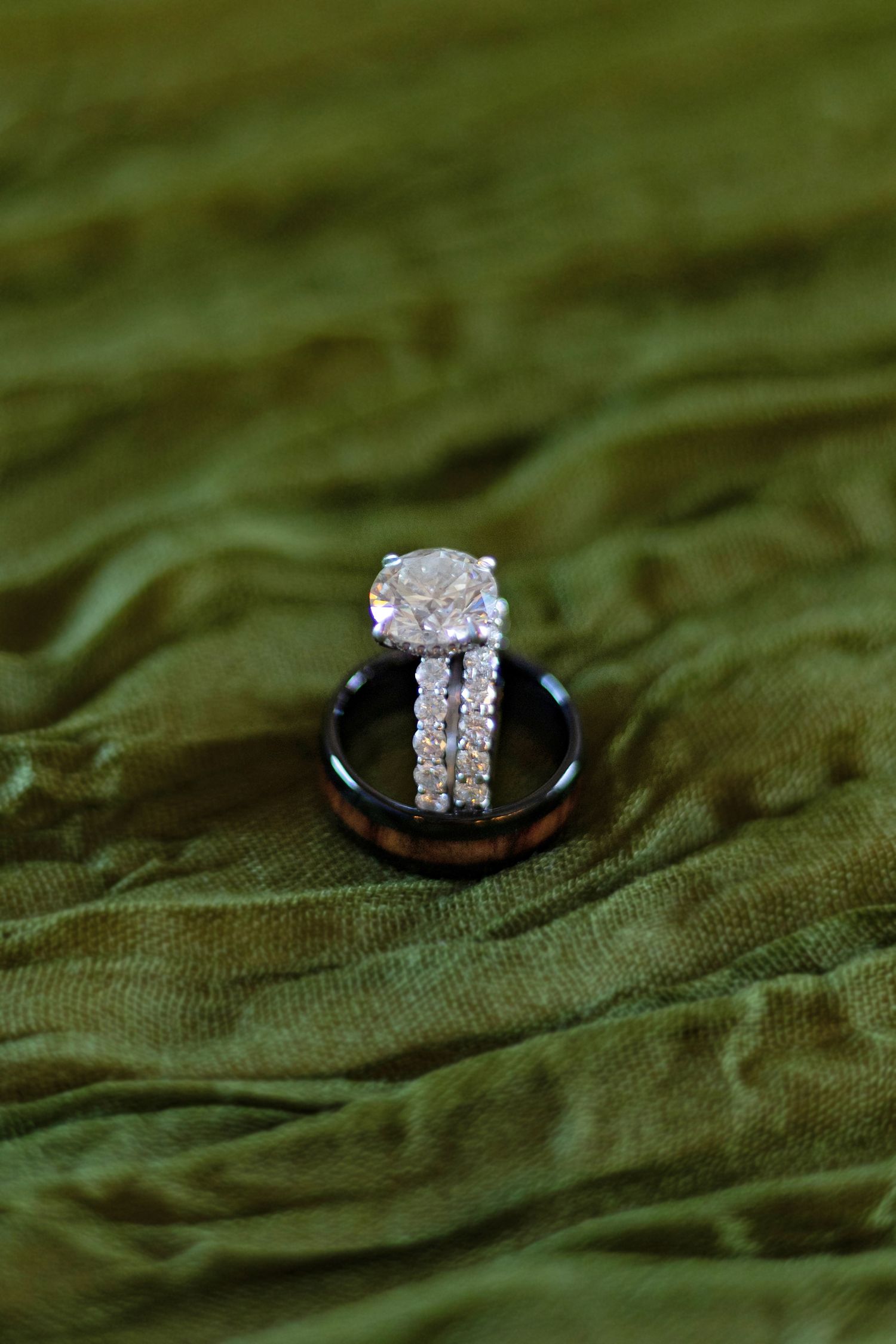 close up of wedding rings on green cloth