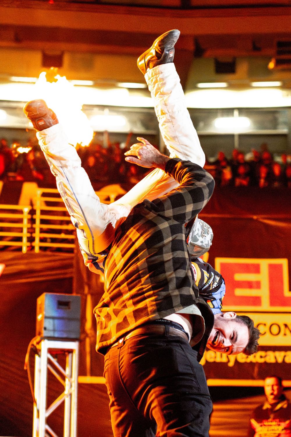 A sequence showing a performer doing an acrobatic backflip stunt in a plaid shirt on stage.