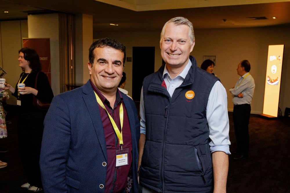 Two people smiling at a professional event