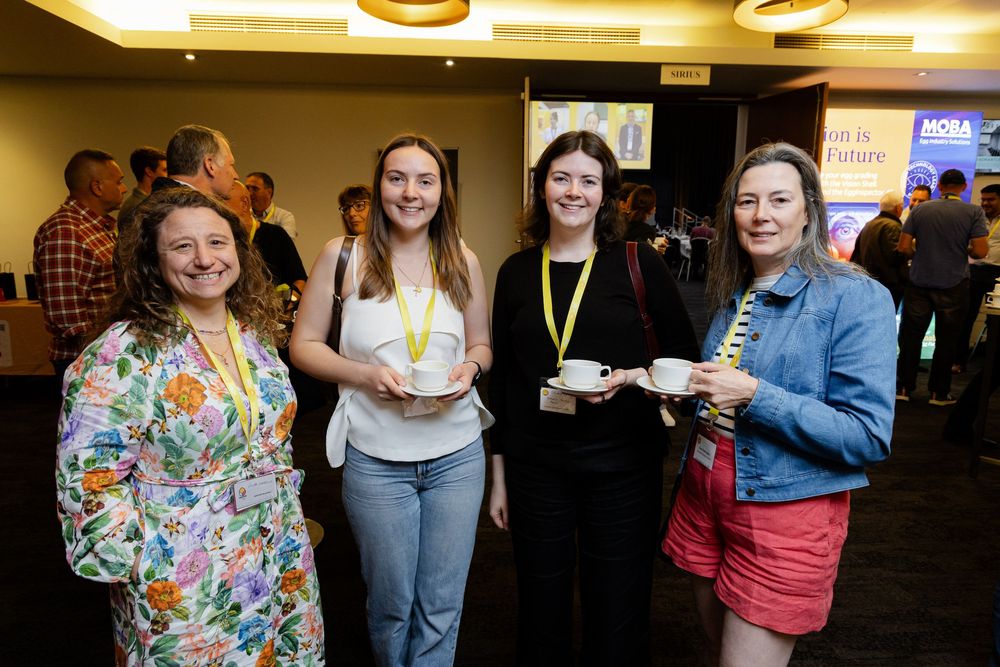 Business networking event with attendees gathered around promotional displays and banners. Fremantle Conference Photos