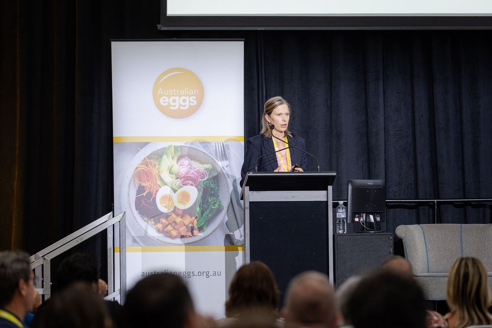 Fremantle Conference Photographer captures talk on conference presentation stage with dark curtain backdrop