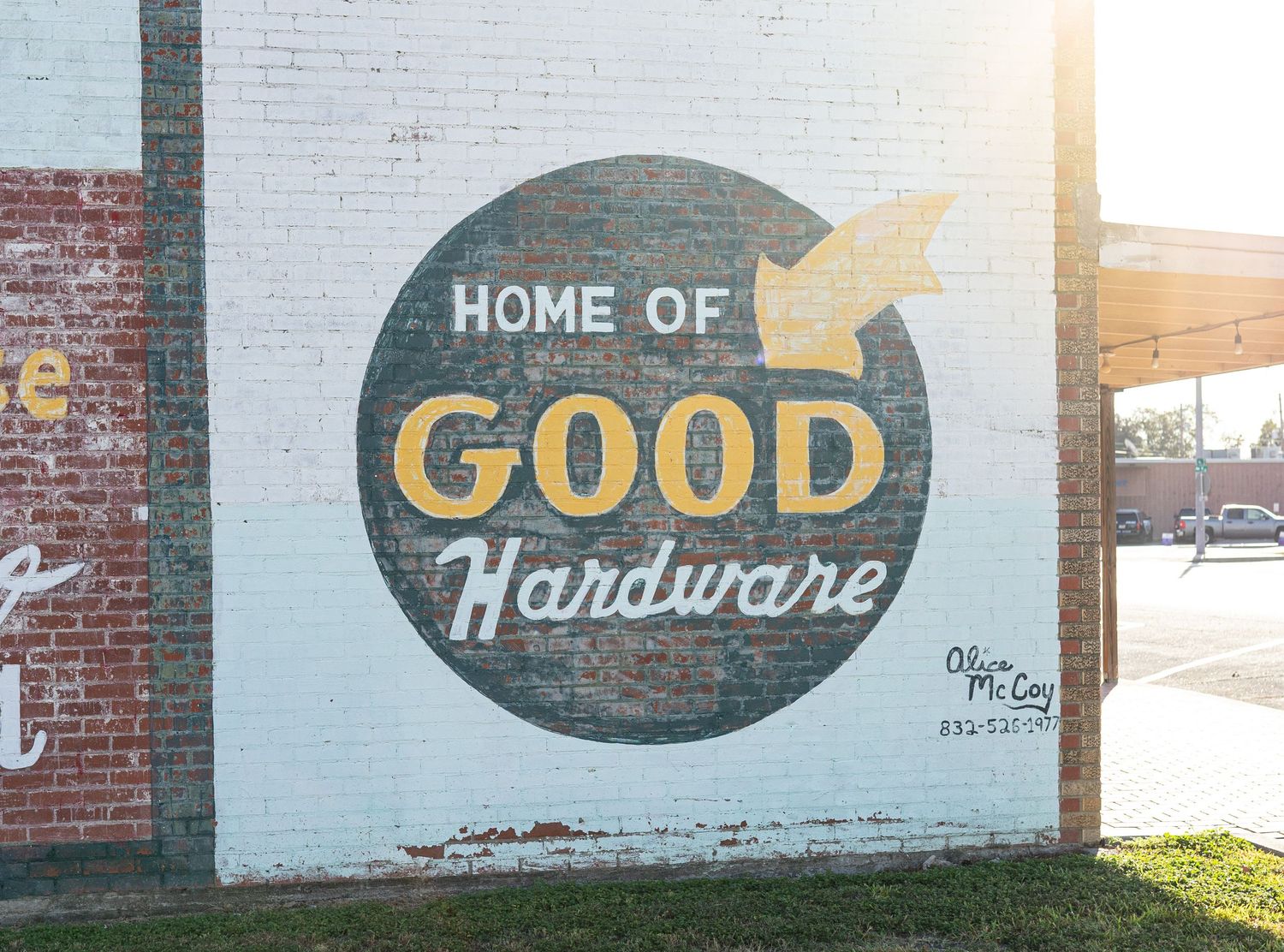 Home of good hardware outdoor painting on red brick at Bay City TX branding session.