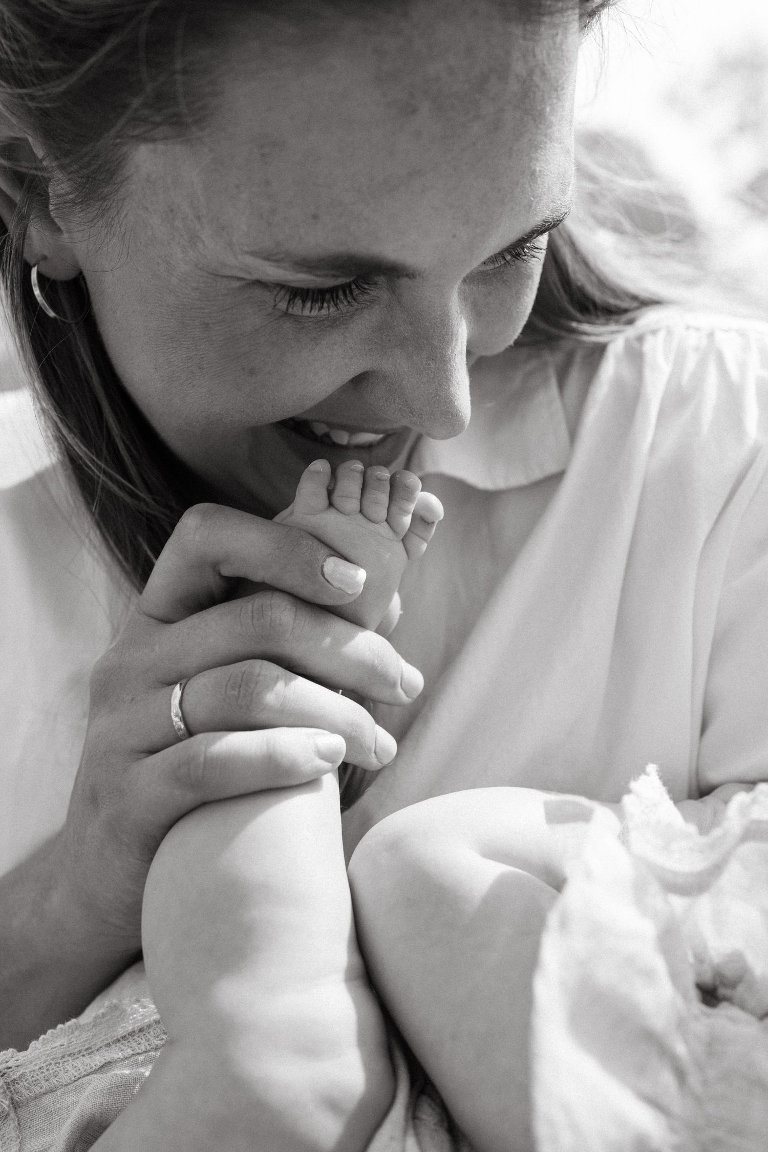 Close-up series showing gentle moments between parent and baby in soft lighting.