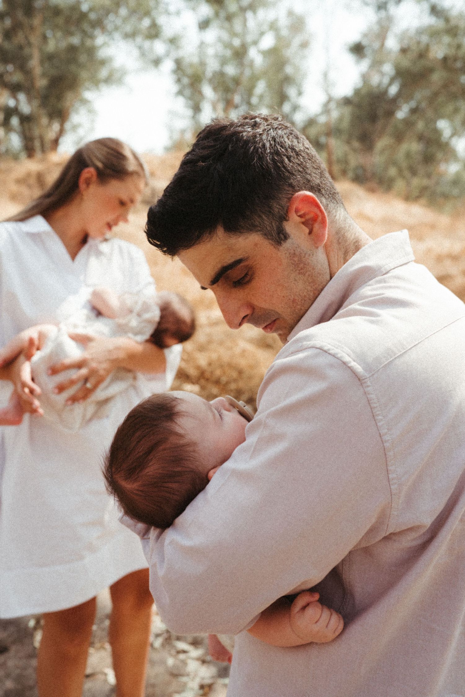 Family photo sequence capturing tender moments with a newborn baby outdoors.
