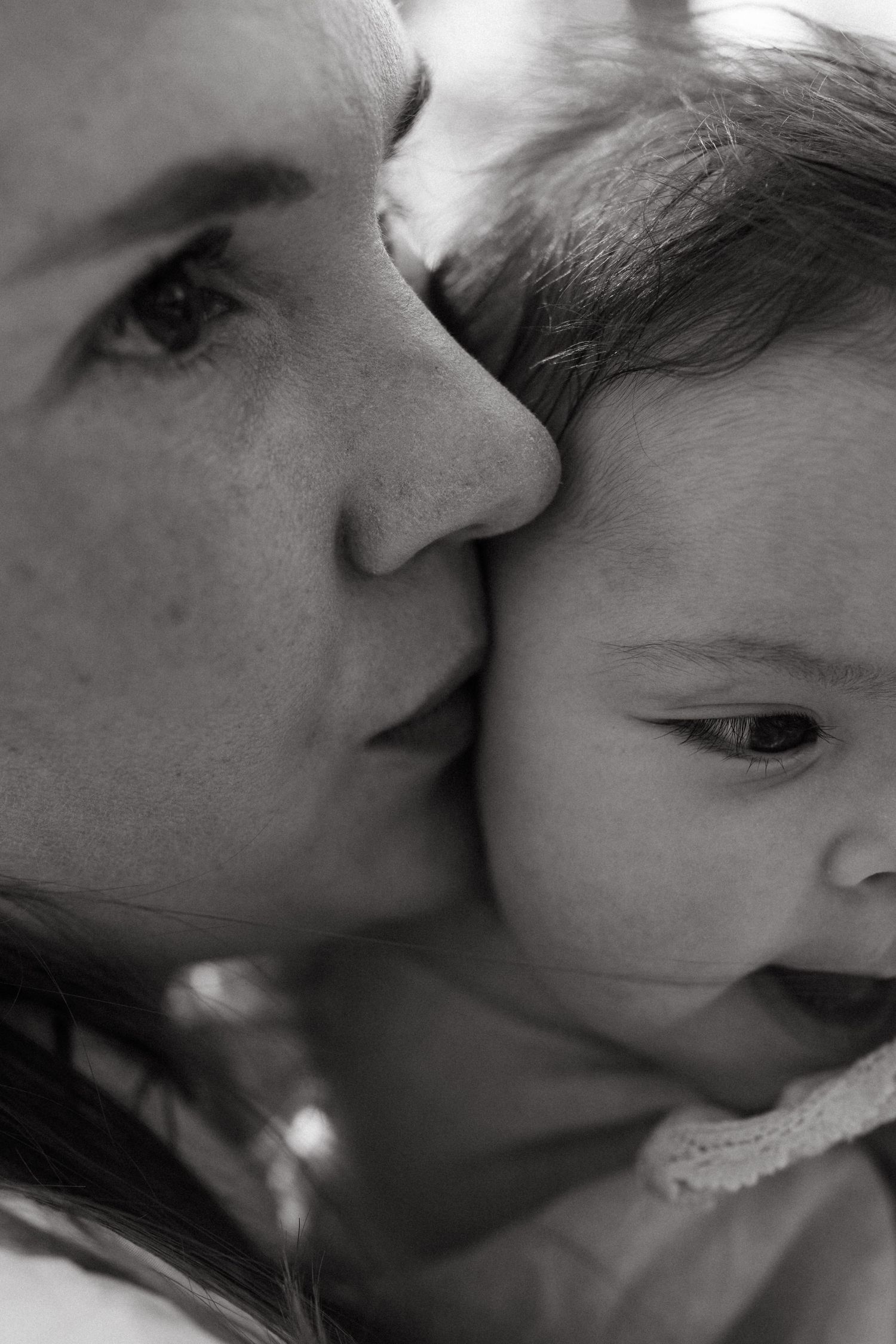 Intimate black and white close-up series of gentle kisses shared with a baby.