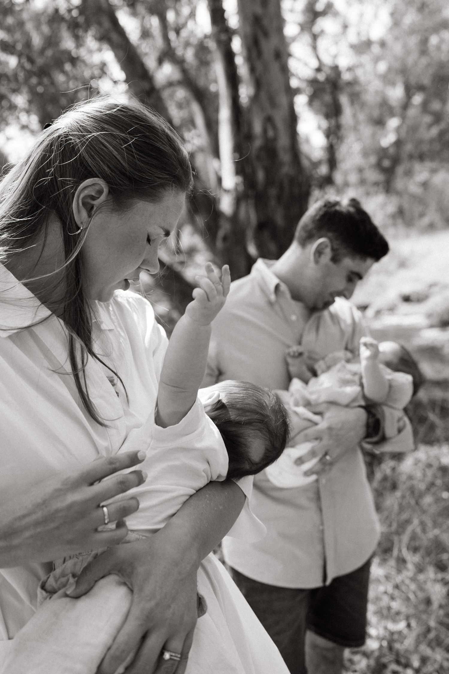 Black and white series of parents sharing affectionate moments with their baby outdoors.