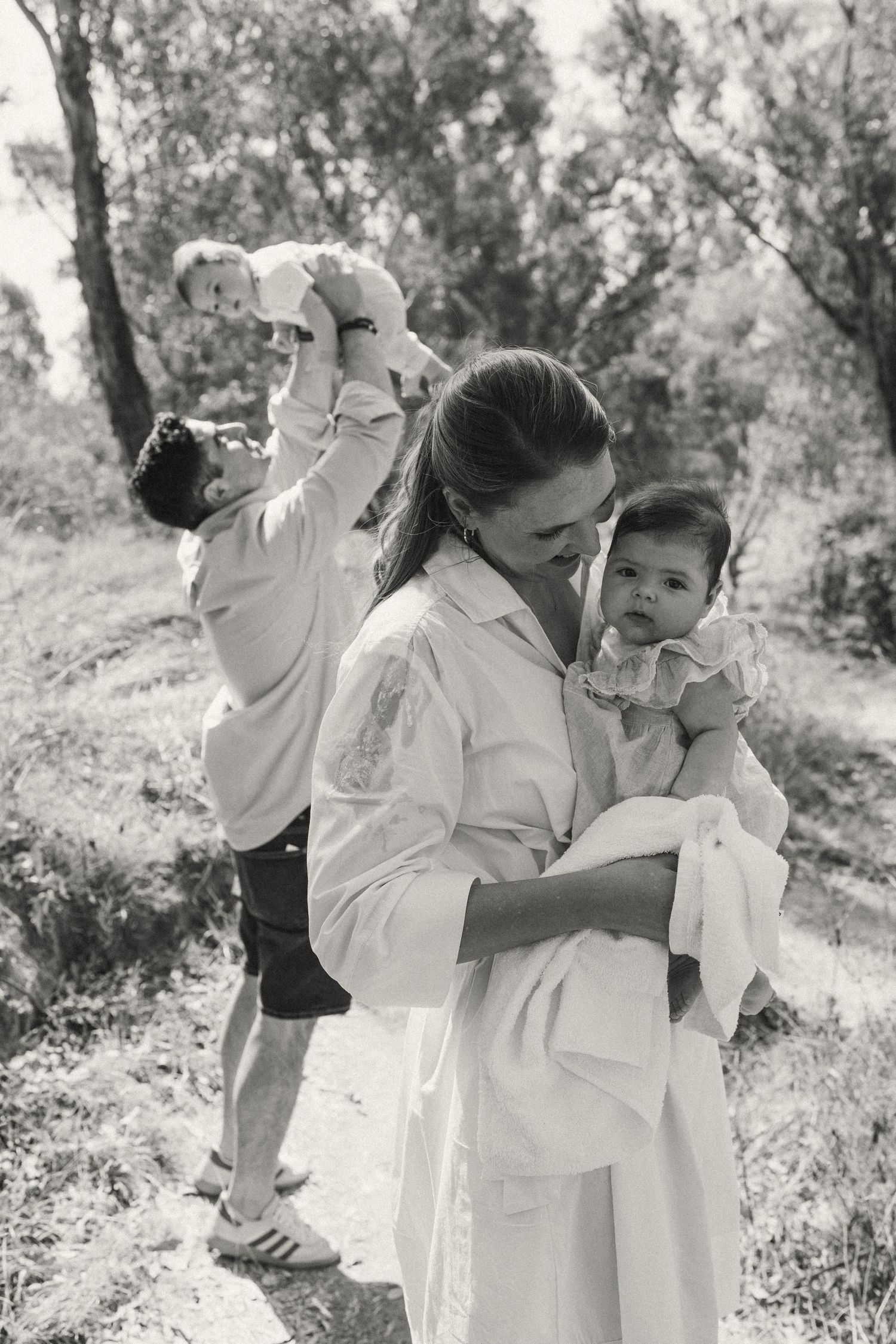 Black and white series of joyful family moments outdoors in natural setting.