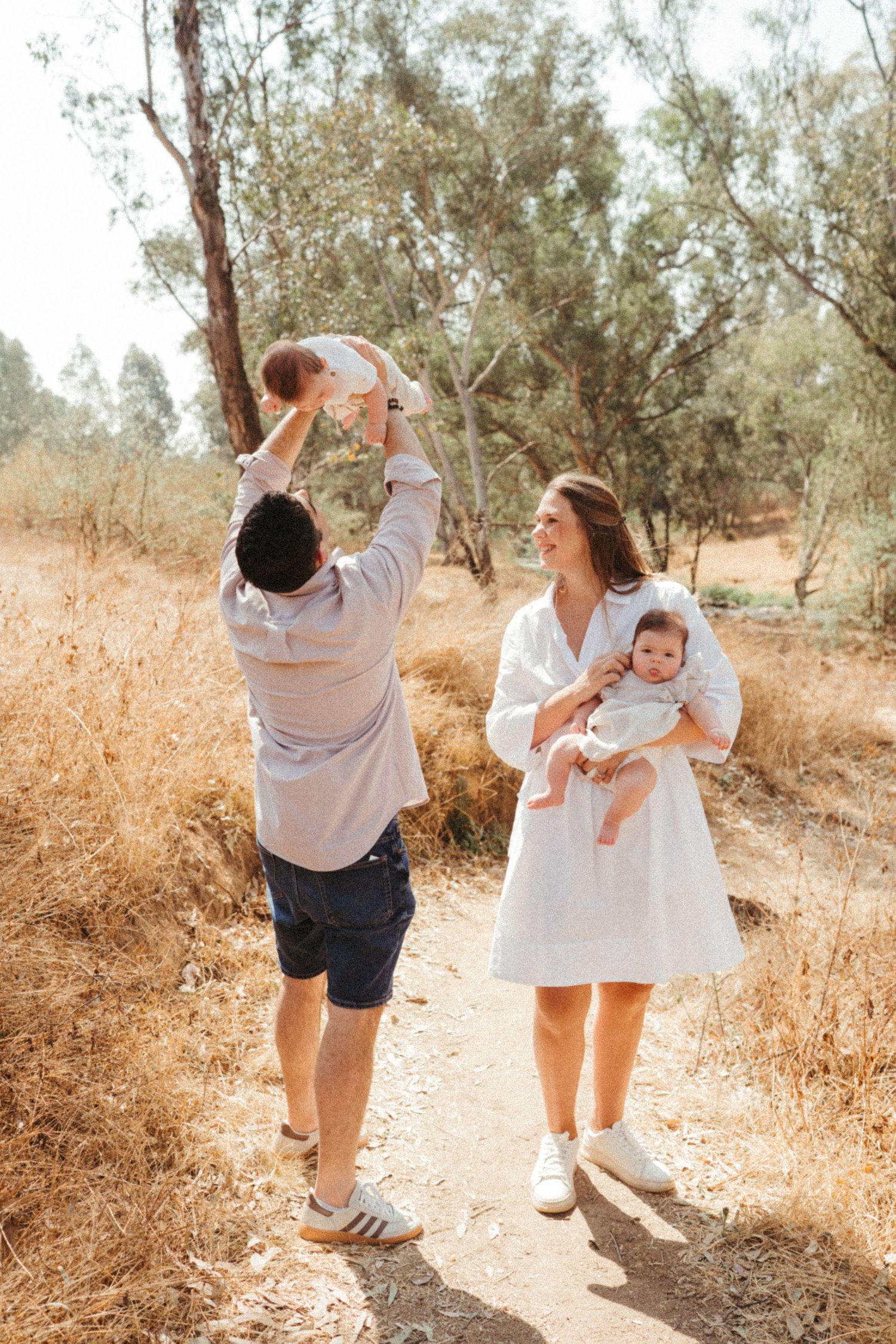 Candid family photos showing playful interactions on a sunny nature trail.