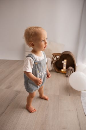 toddler standing looking out window during milestone session at Bishopdale studio