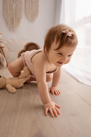 toddler smiling and crawling during milestone session at Bishopdale studio. Christchurch