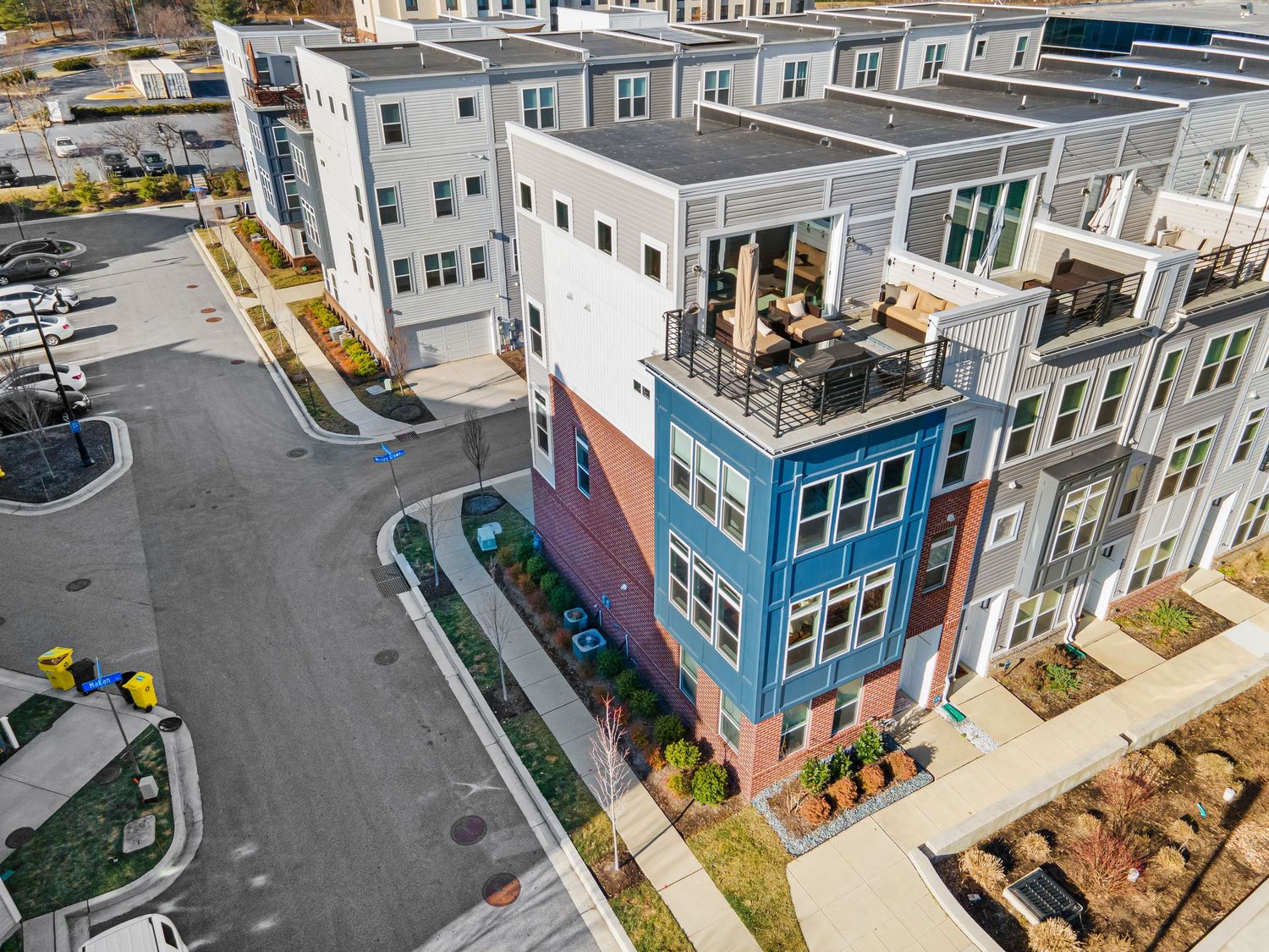 Aerial view of contemporary urban townhouses with mixed materials and rooftop decks.
