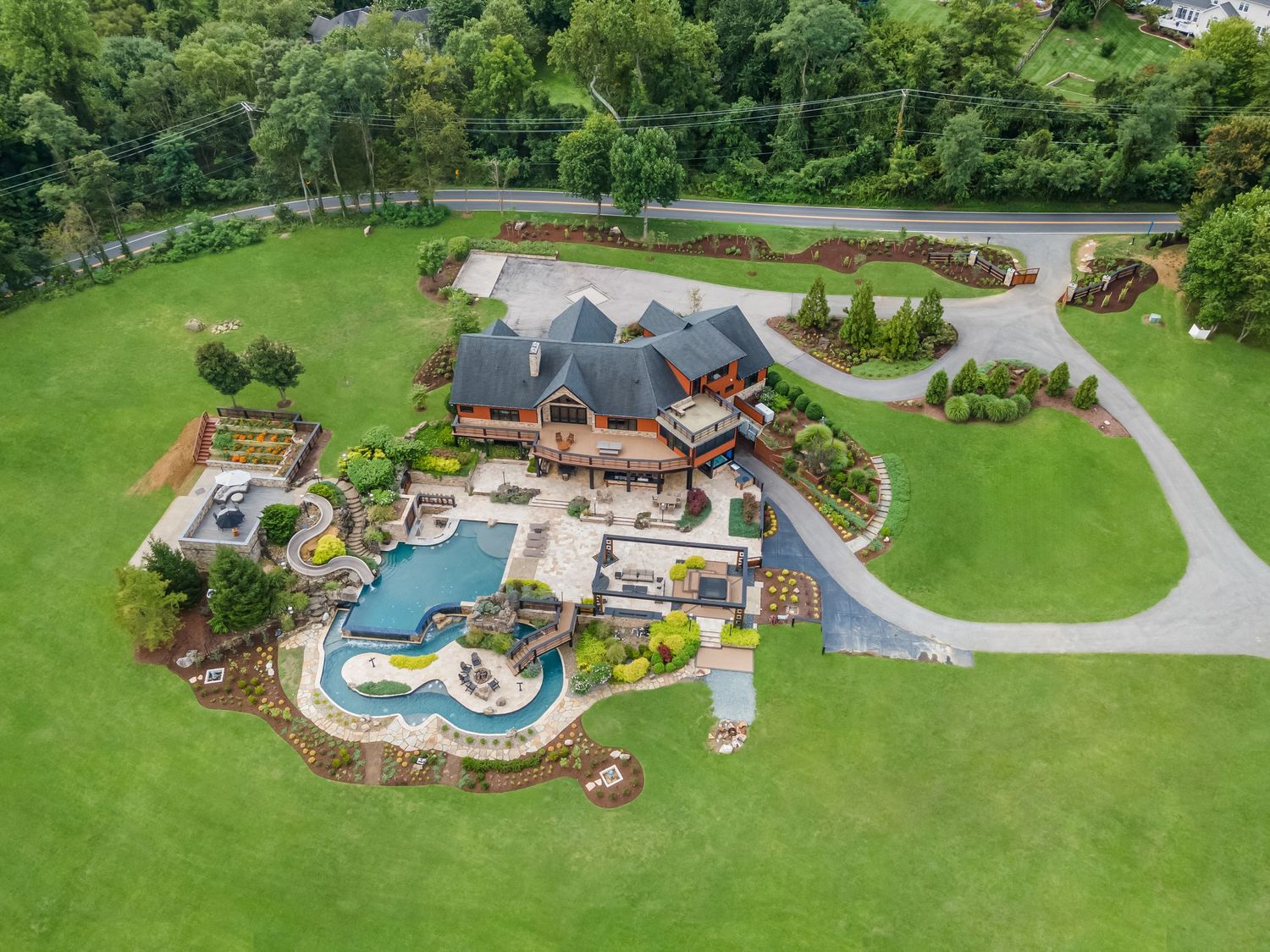Stunning backyard featuring a custom swimming pool with water features and extensive landscaping.