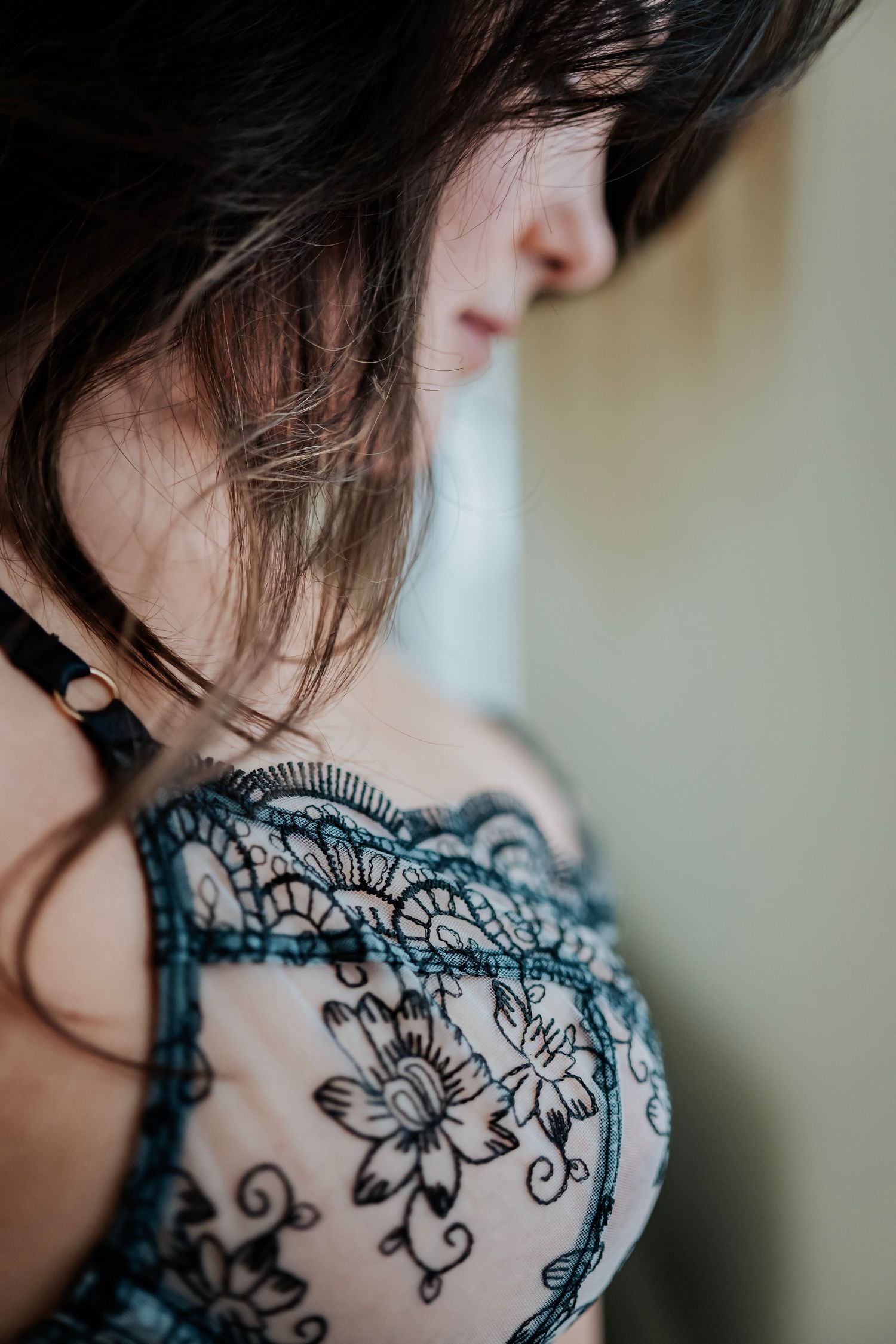 Artistic close-up of black lace lingerie with floral embroidery pattern.