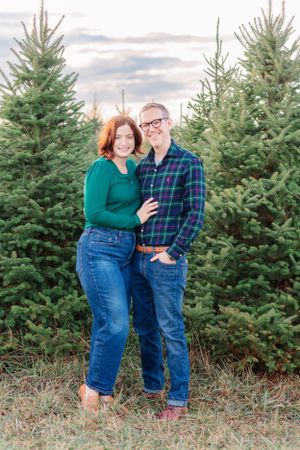 A couple poses together at a Christmas tree farm in Mason, Michigan.