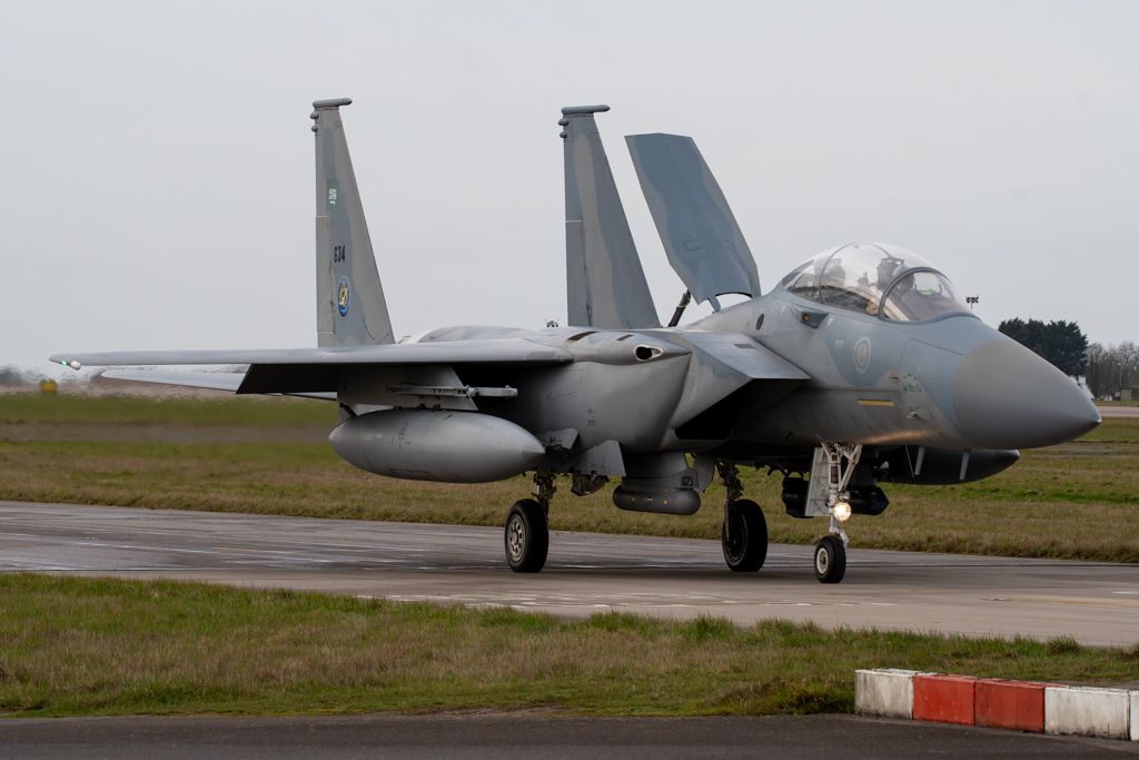 Saudi Air Force F-15 Eagle fighter jet on tarmac taxiway.