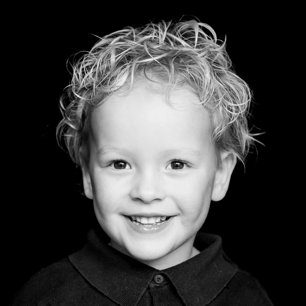 Black and white portrait series showing joyful expressions and messy blonde hair against dark background.