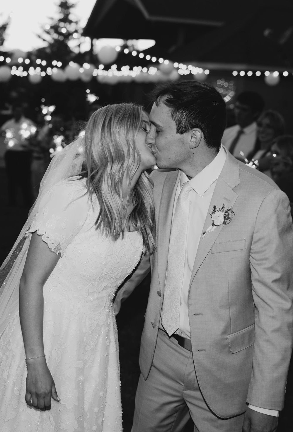 A romantic black and white series of wedding photos showing tender kisses between a couple in formal attire.