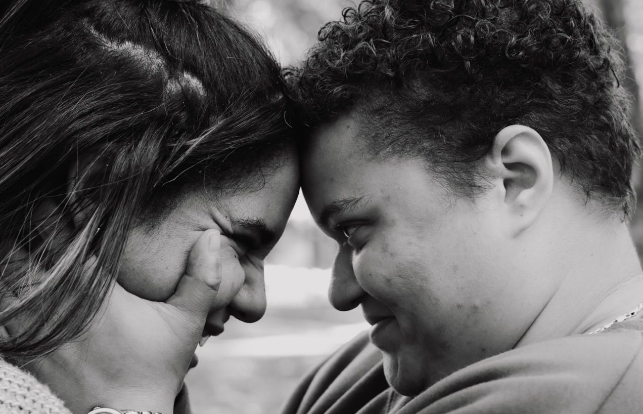 Two young women in love. Black and white image of one caressing the others face.