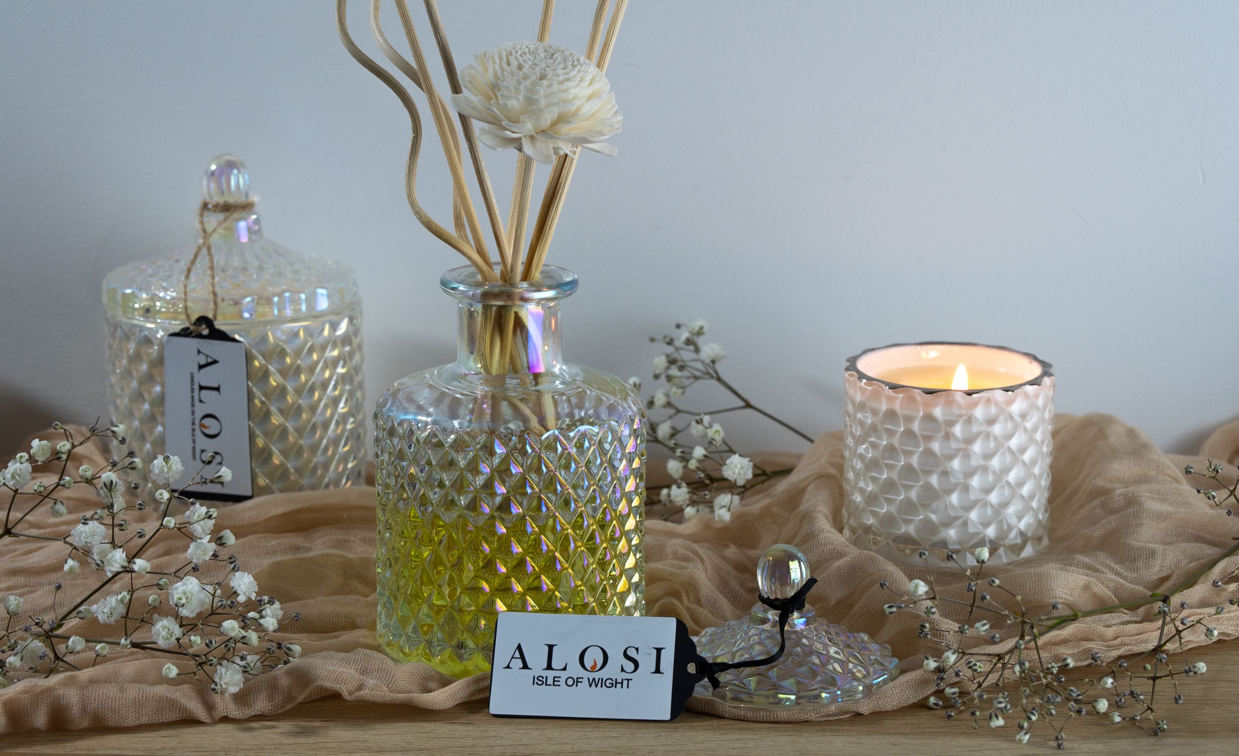 Decorative glass candle holders and vases arranged with tealights on a wooden surface create a cozy ambiance.