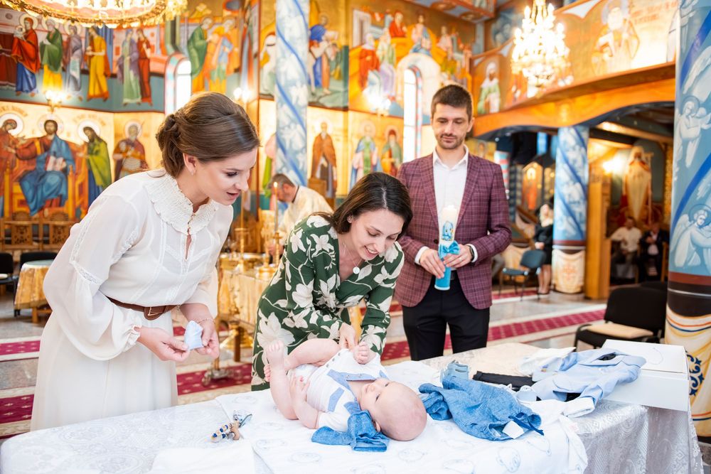 Couple signing wedding documents in ornate church interior with colorful murals and decorative elements.