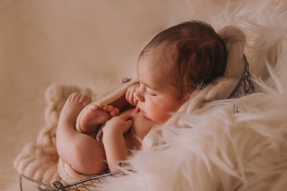 A sleeping baby lies peacefully on soft white bedding in a series of connected photos.