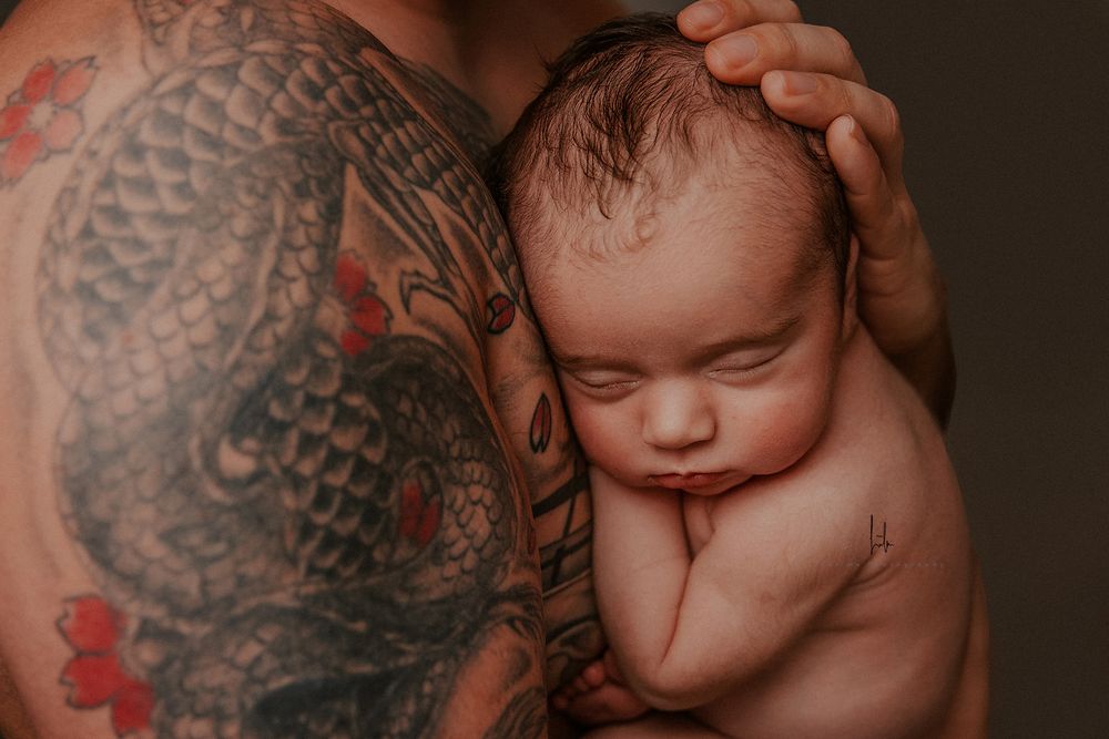 Close-up artistic photo showing intricate tattoo details and soft skin tones in warm lighting.