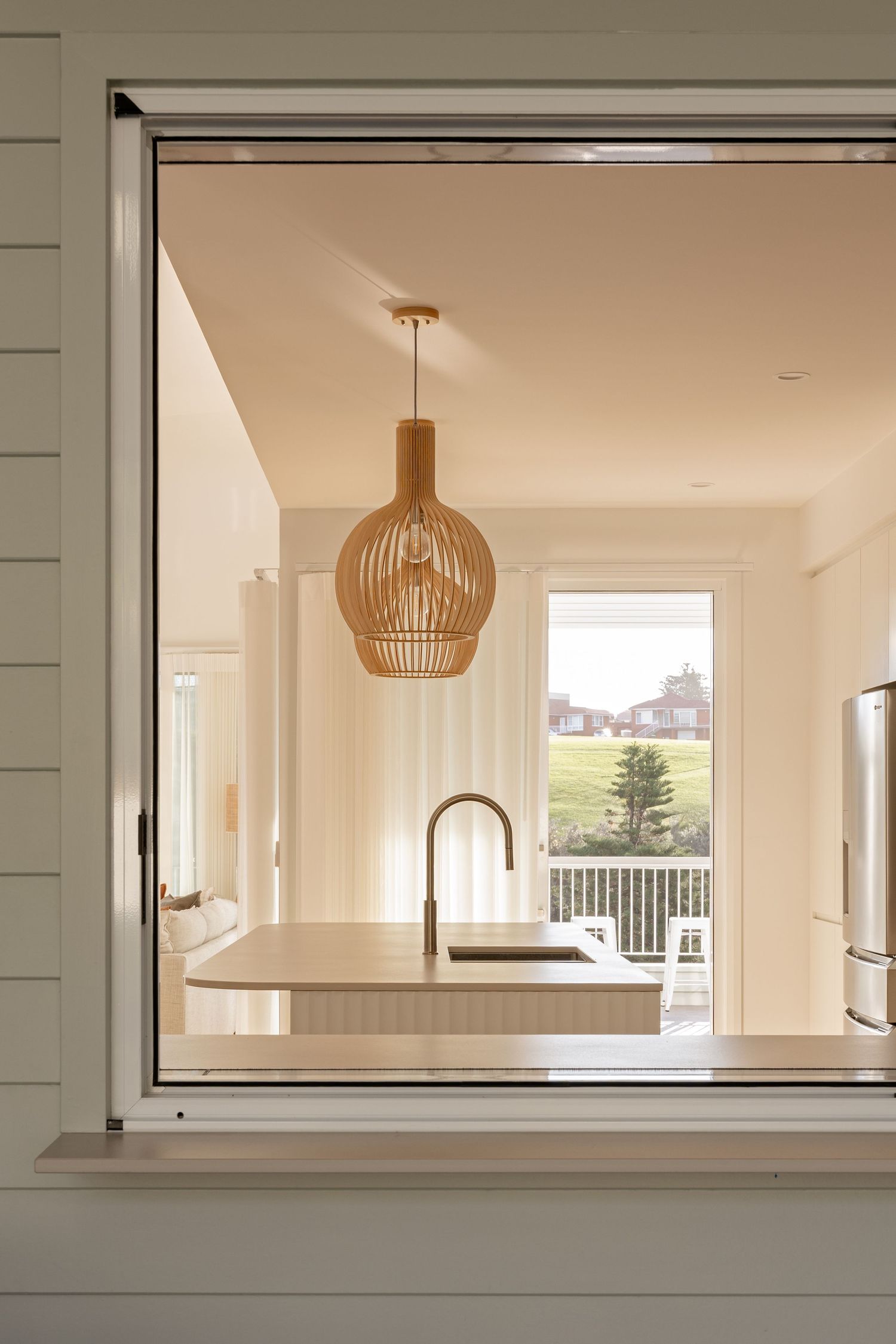 A series of modern interior windows with bamboo pendant lights showing a bright, minimalist architectural design.