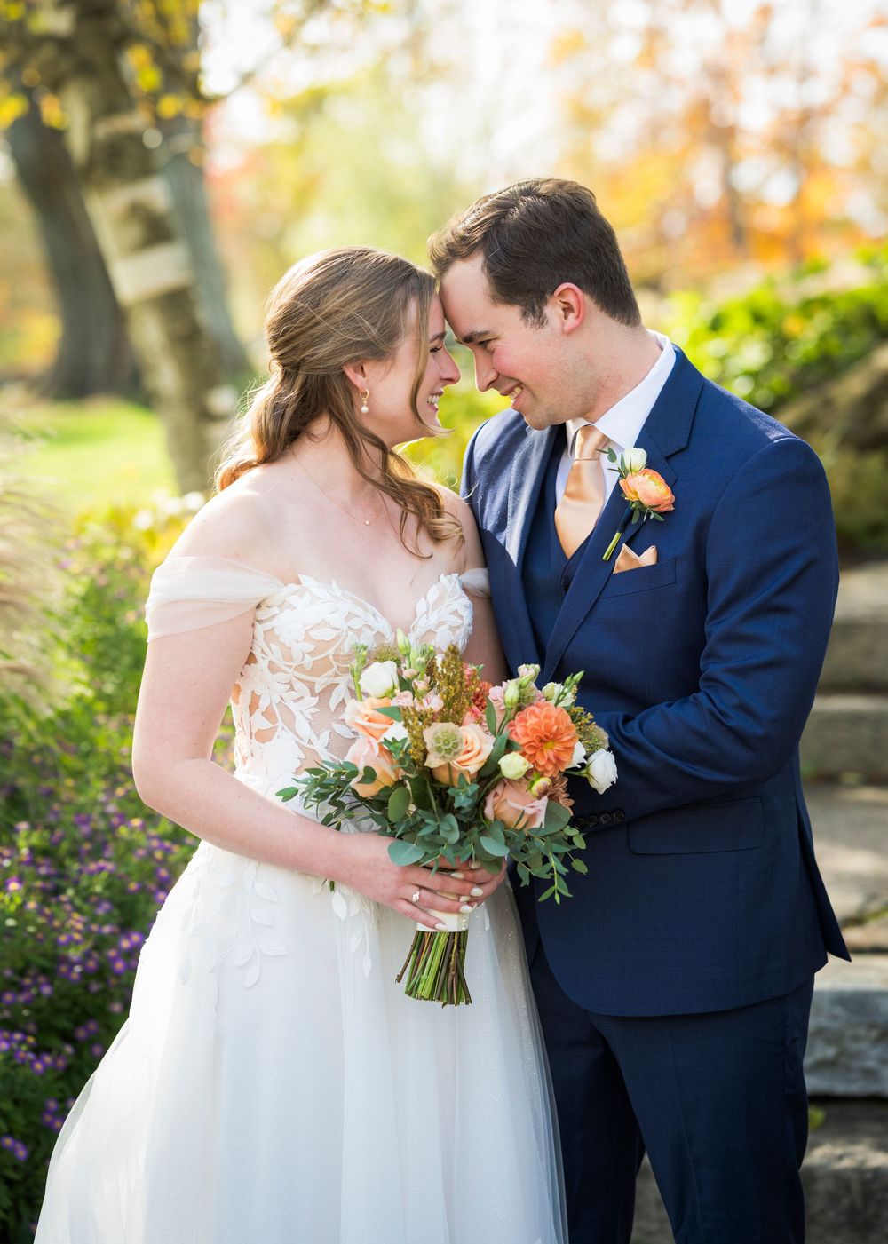 A romantic wedding couple shares intimate moments in an autumn garden setting with warm golden light and florals.