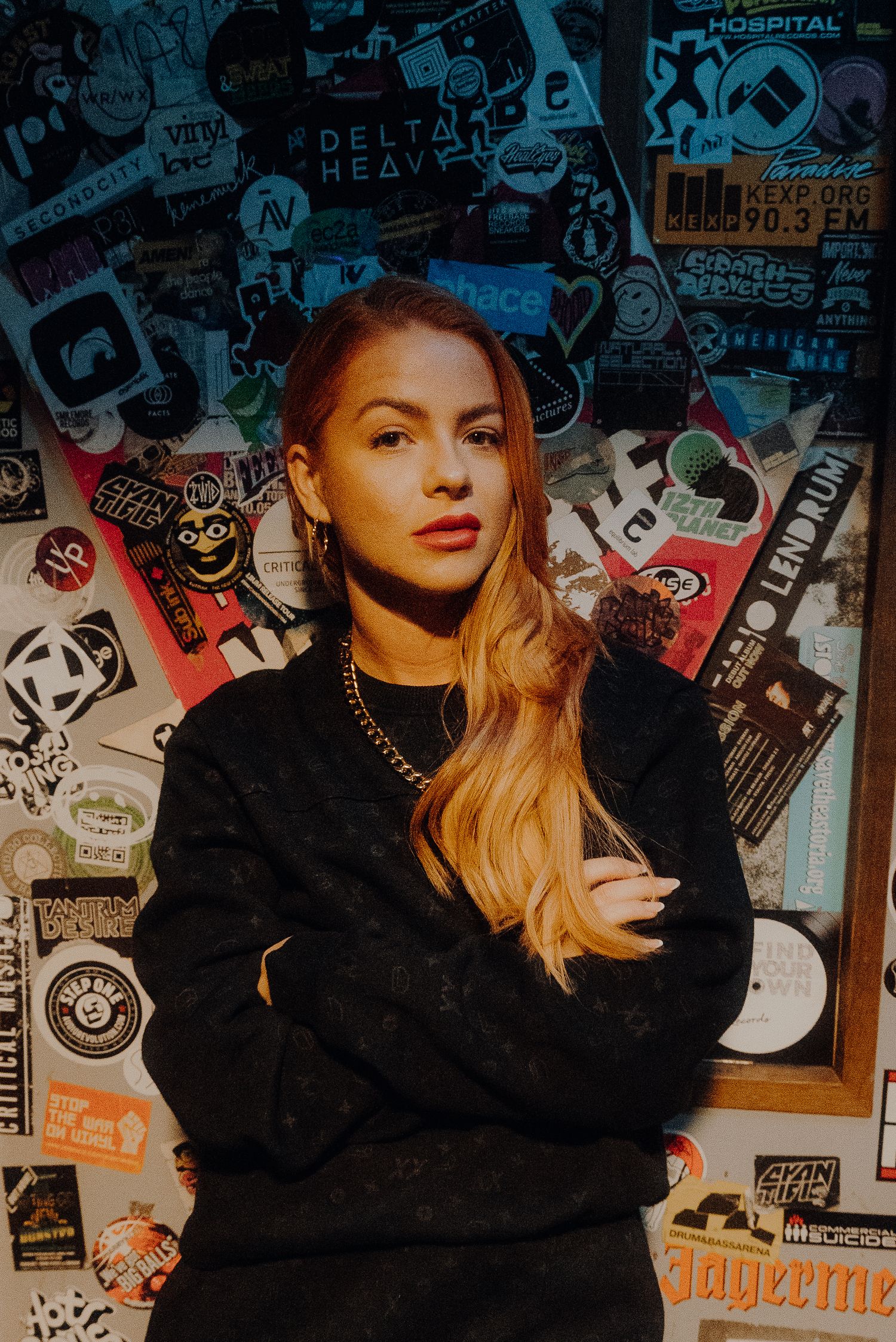 Portrait against wall covered in music and entertainment stickers and posters.