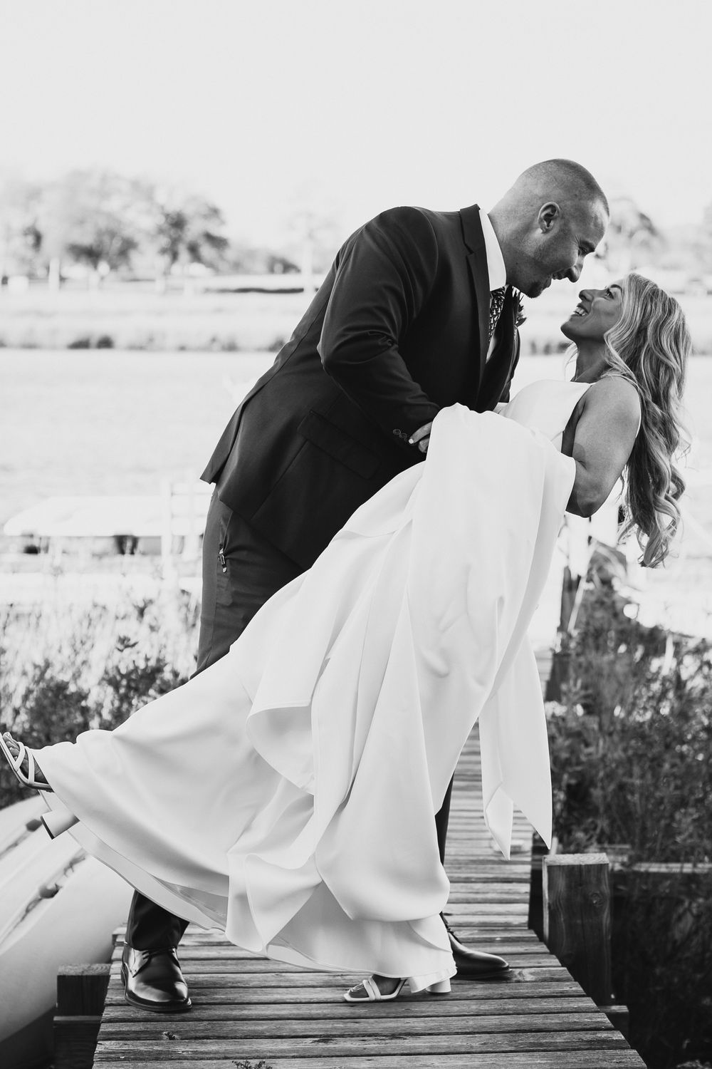 A romantic black and white photo sequence shows a couple in wedding attire sharing an intimate dip kiss on a wooden deck.
