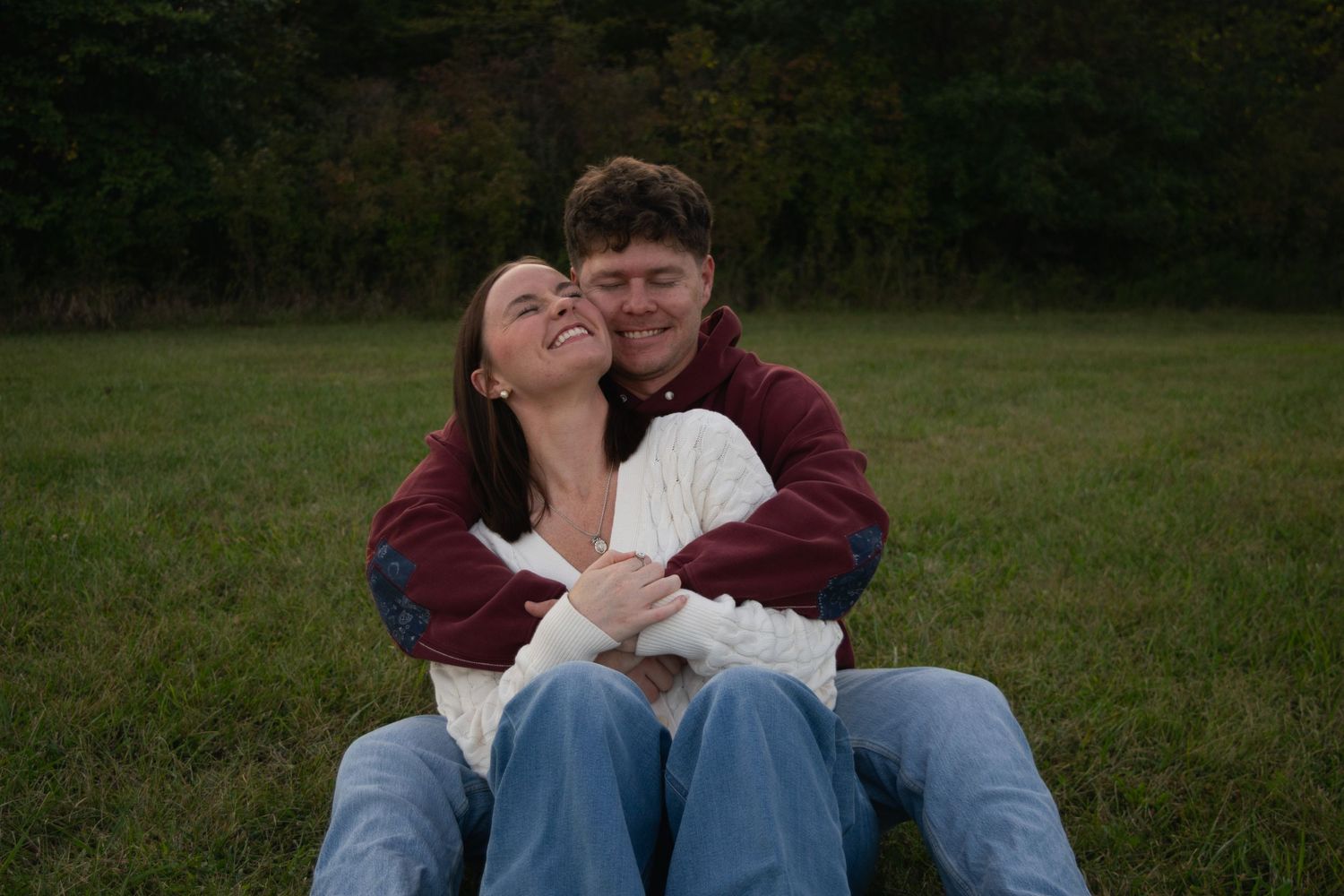 Woman sitting in between man's legs, rocking back and forth and hugging each other
