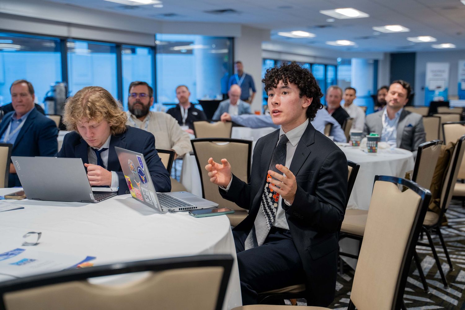 Business professionals seated in a modern office conference room during a meeting or presentation.