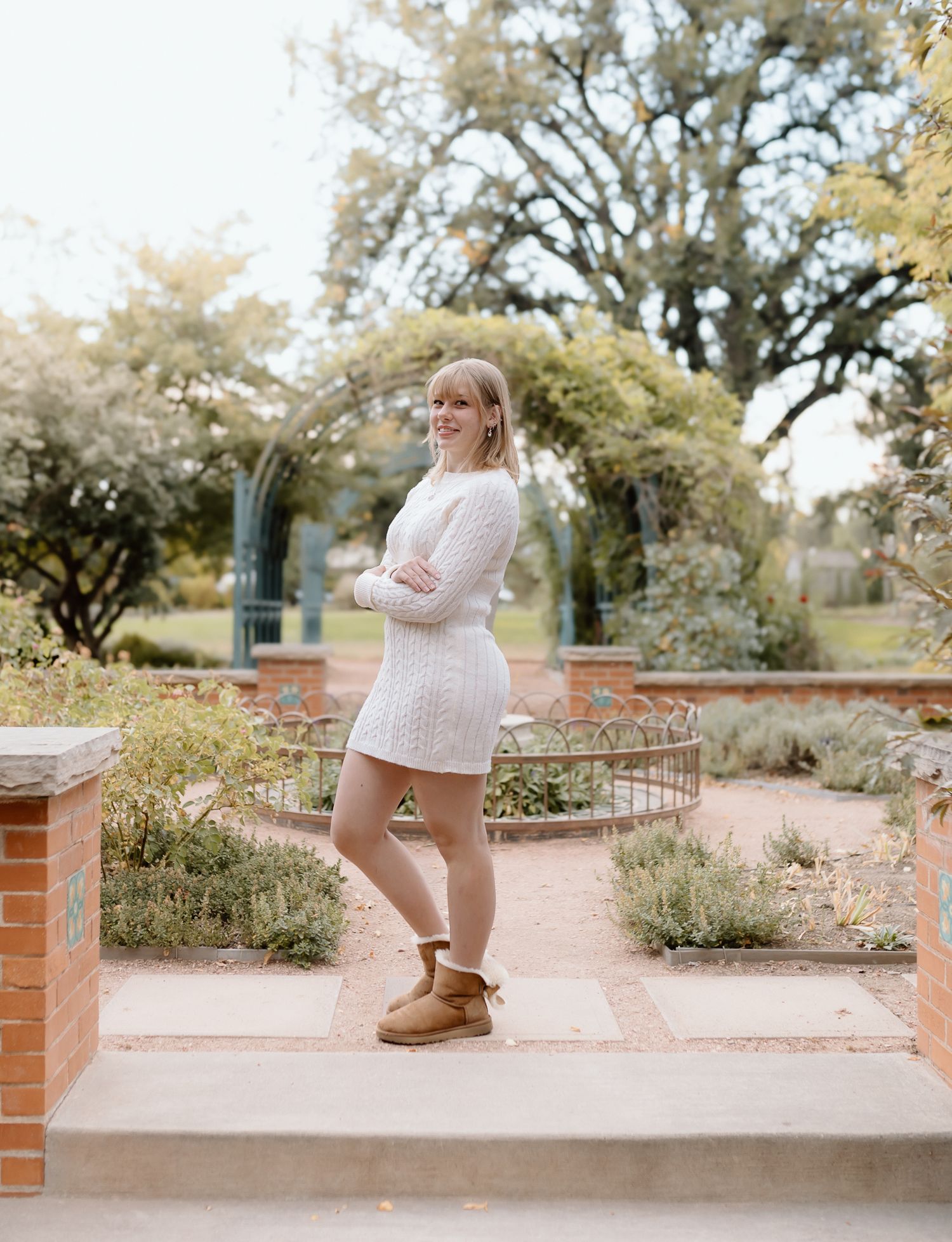 A series of connected photos shows a person in a cozy sweater and boots walking along a brick-lined garden path.