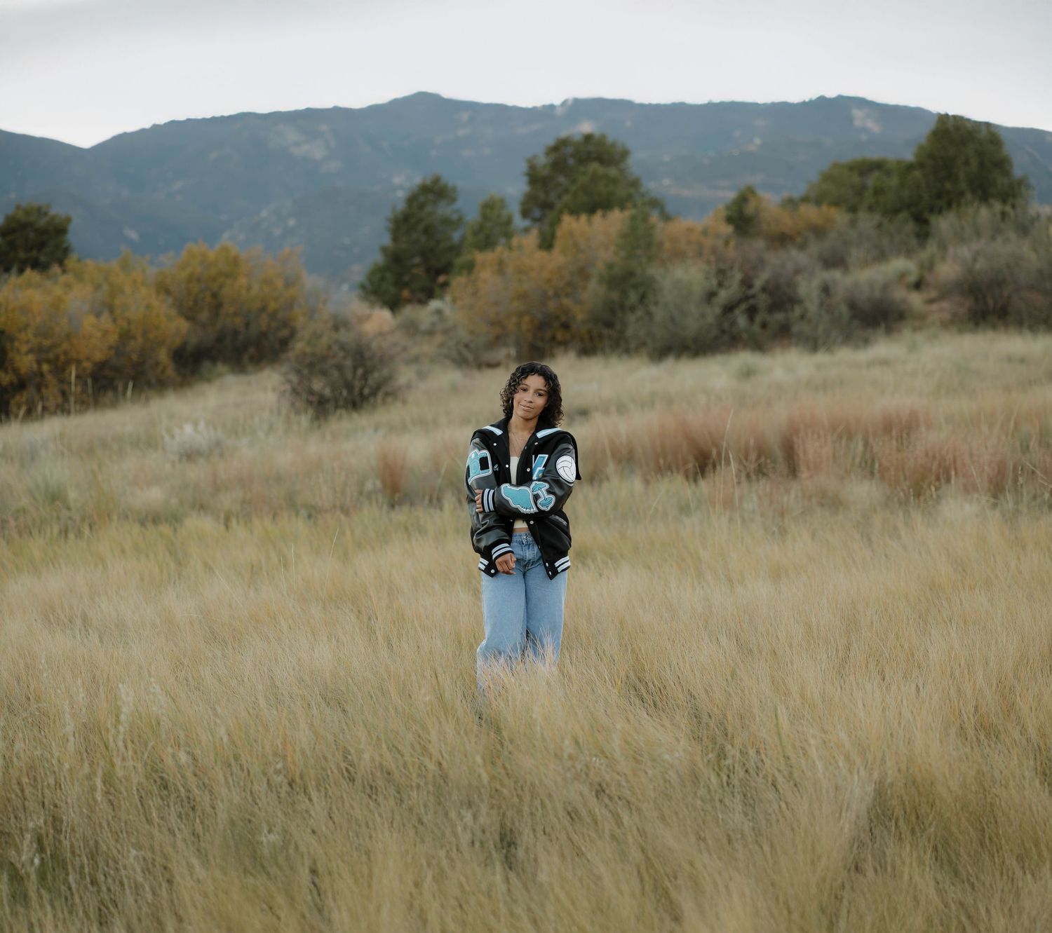 A series of outdoor portraits in a golden grassy field with mountains in the background.