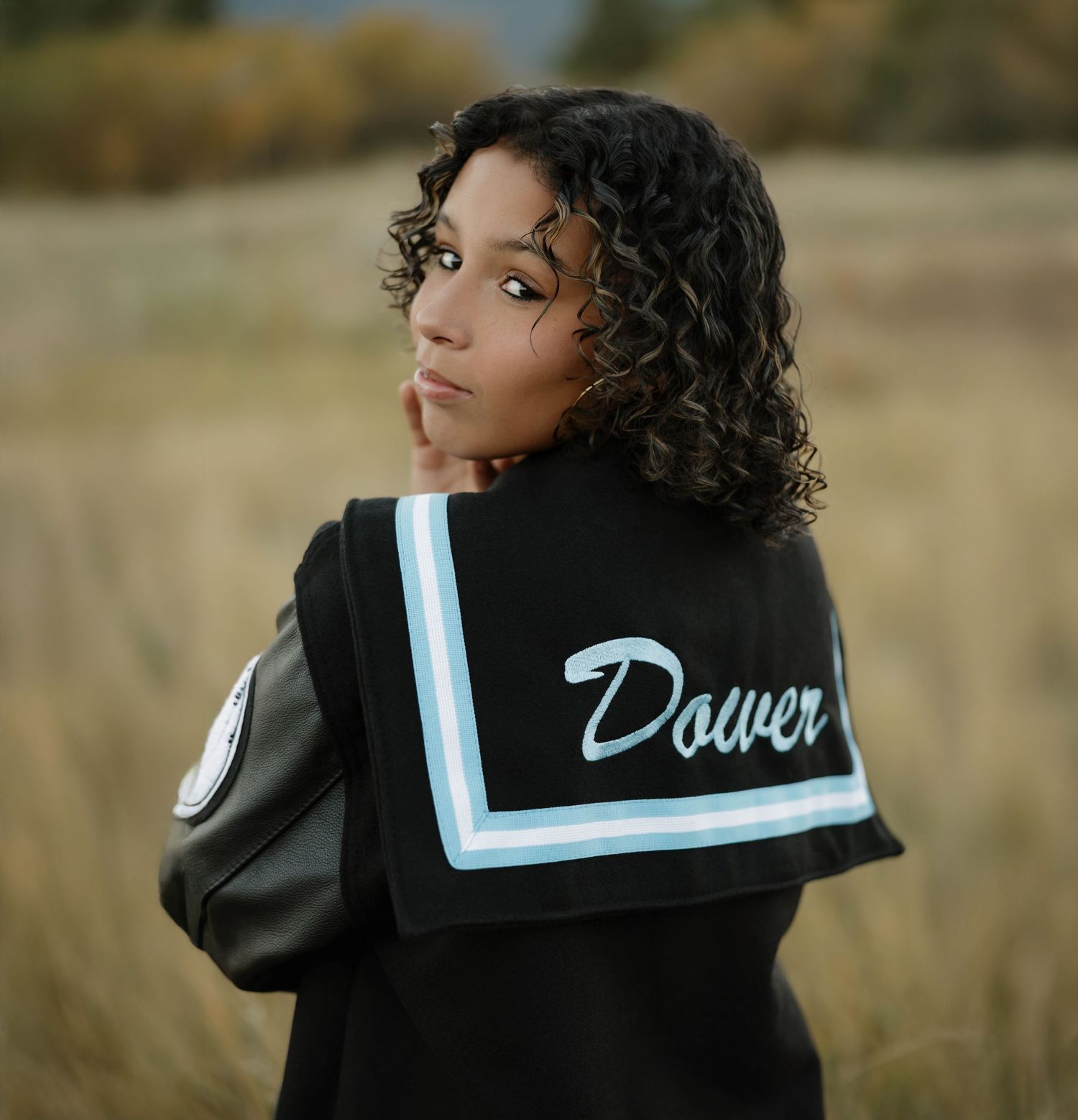 Black jacket with light blue sailor collar detail shown from different angles in outdoor setting.