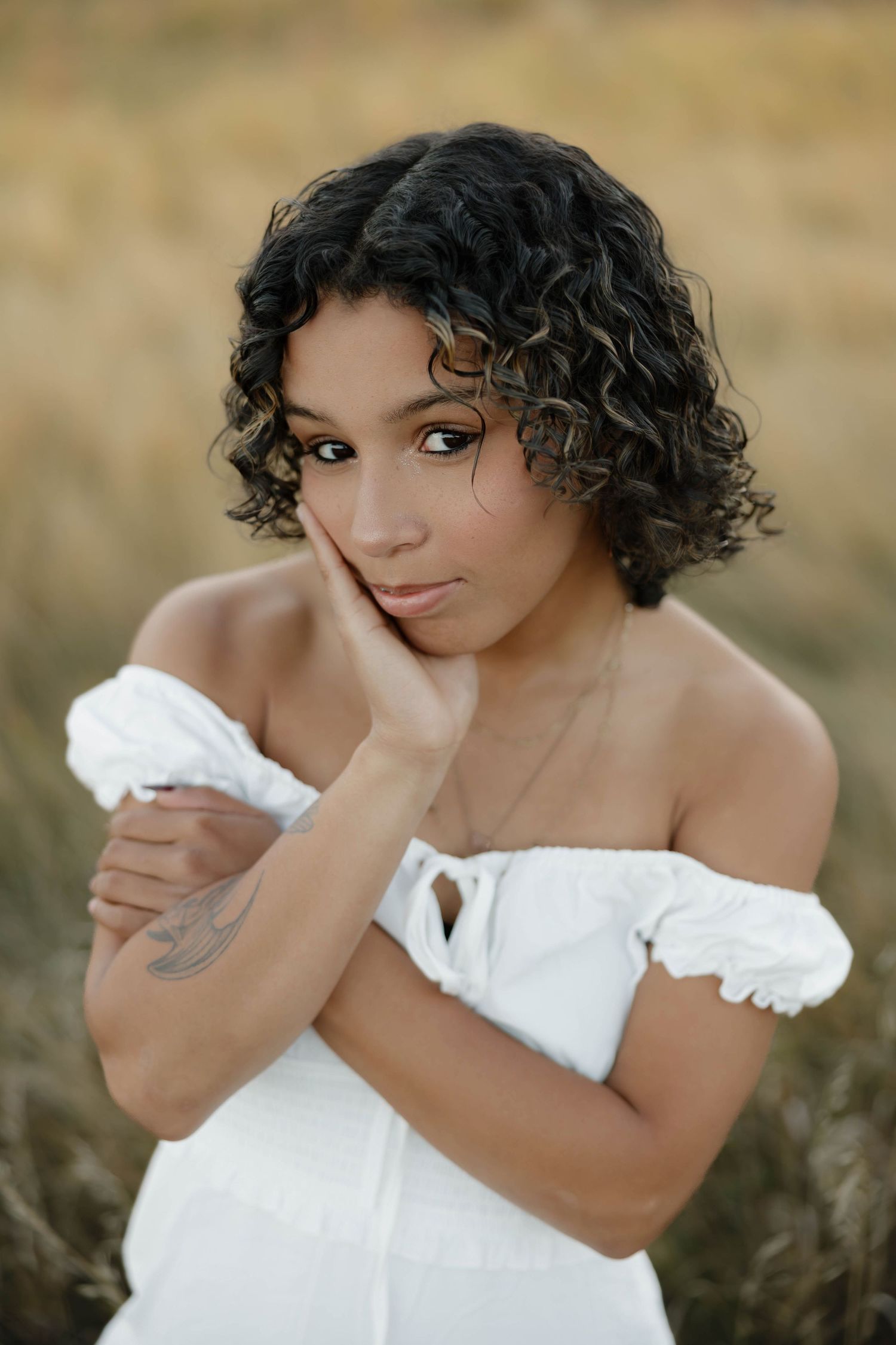A sequence of romantic outdoor portraits showing someone in a white off-shoulder dress with curly hair.