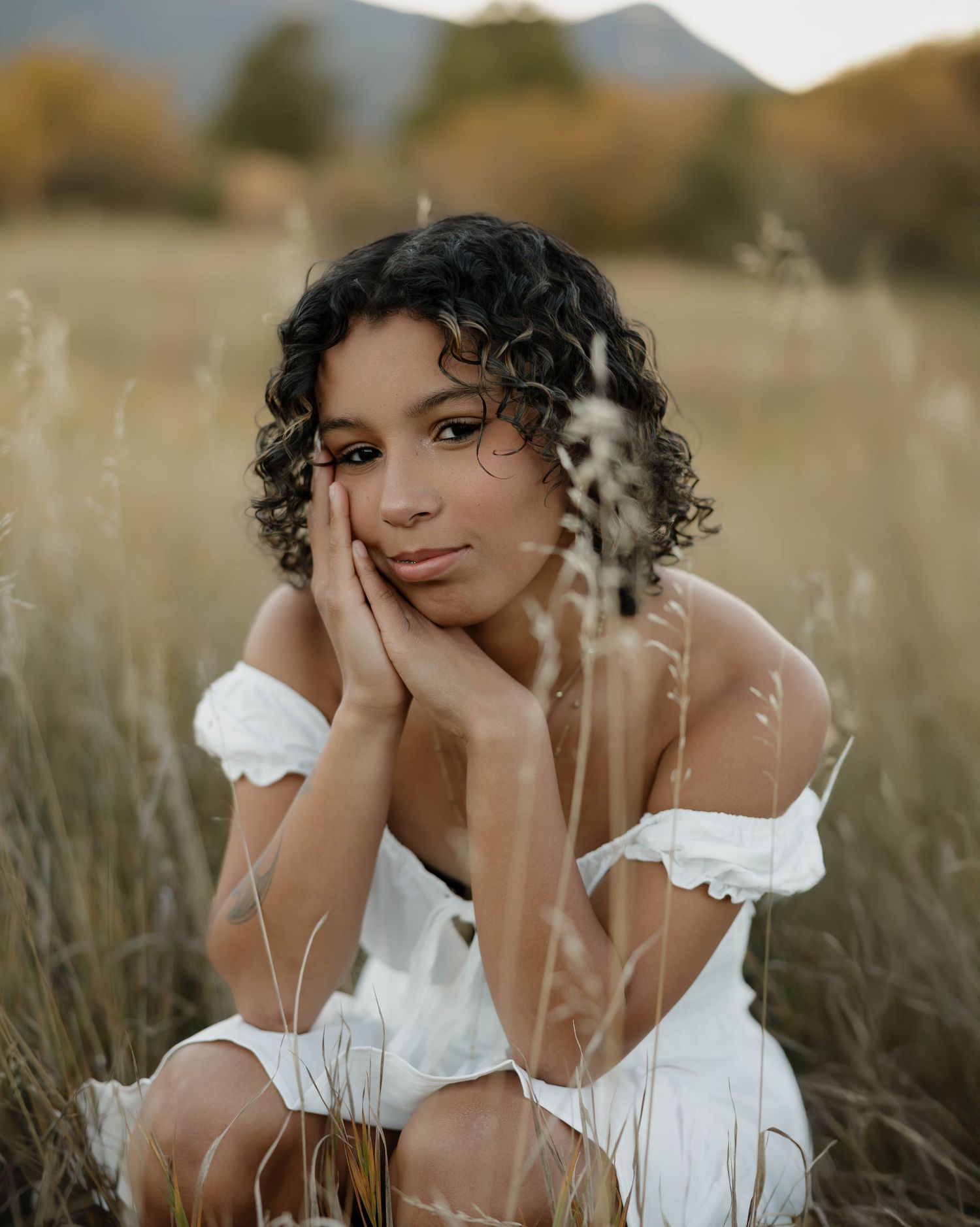 Artistic portraits in a sunlit field showcase romantic styling with a white peasant top.