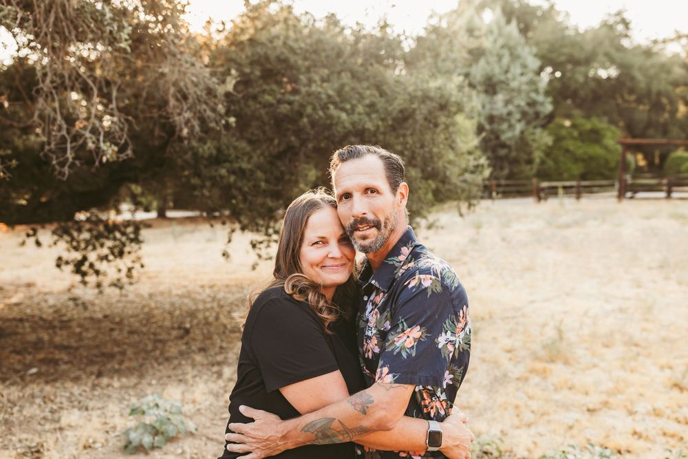 Couple sharing tender moments in a sunlit outdoor setting during a romantic photo session.