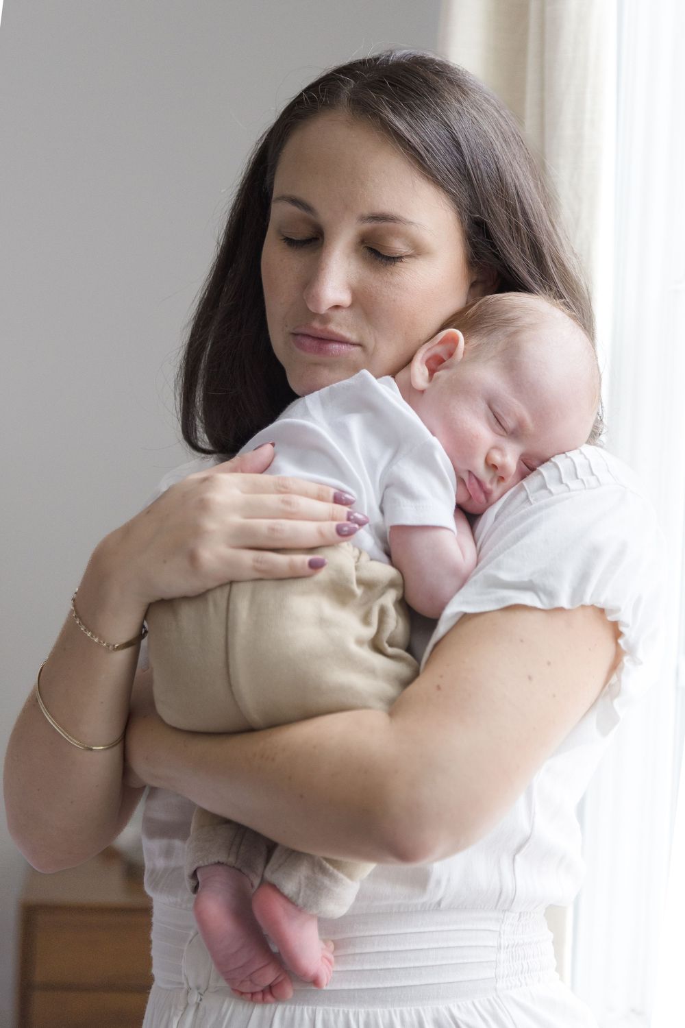 "Newborn baby sleeping peacefully on mother's shoulder during elegant Washington DC lifestyle newborn session."