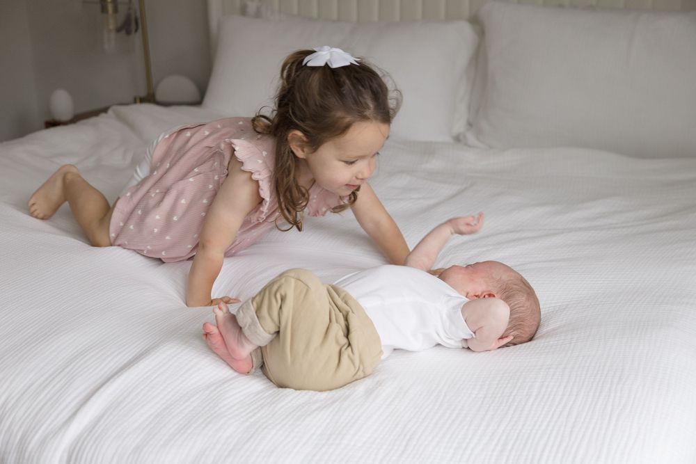 "Toddler lovingly gazing at newborn brother during an elegant in-home luxury newborn session in Washington, DC"