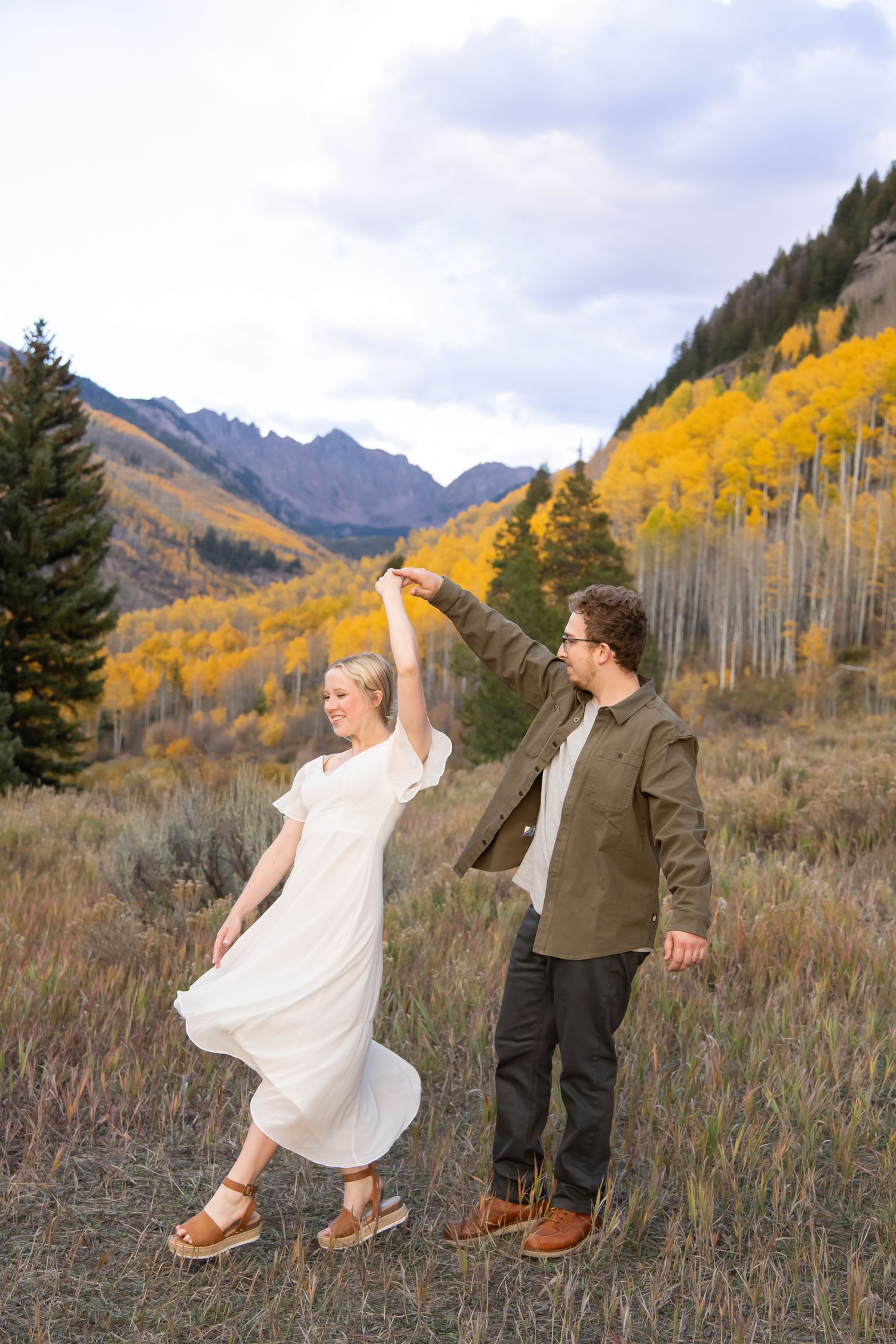 Vail fall engagement photos with mountain background and yellow aspen leaves with fall foliage