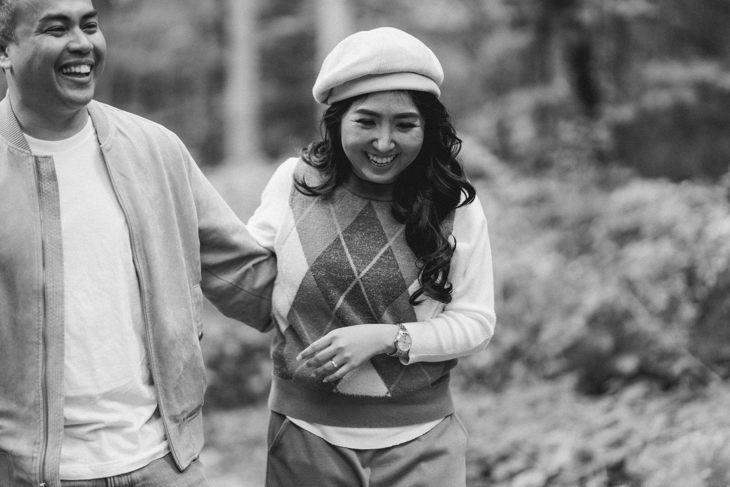 Group of people enjoying a candid moment outdoors while laughing and smiling together.