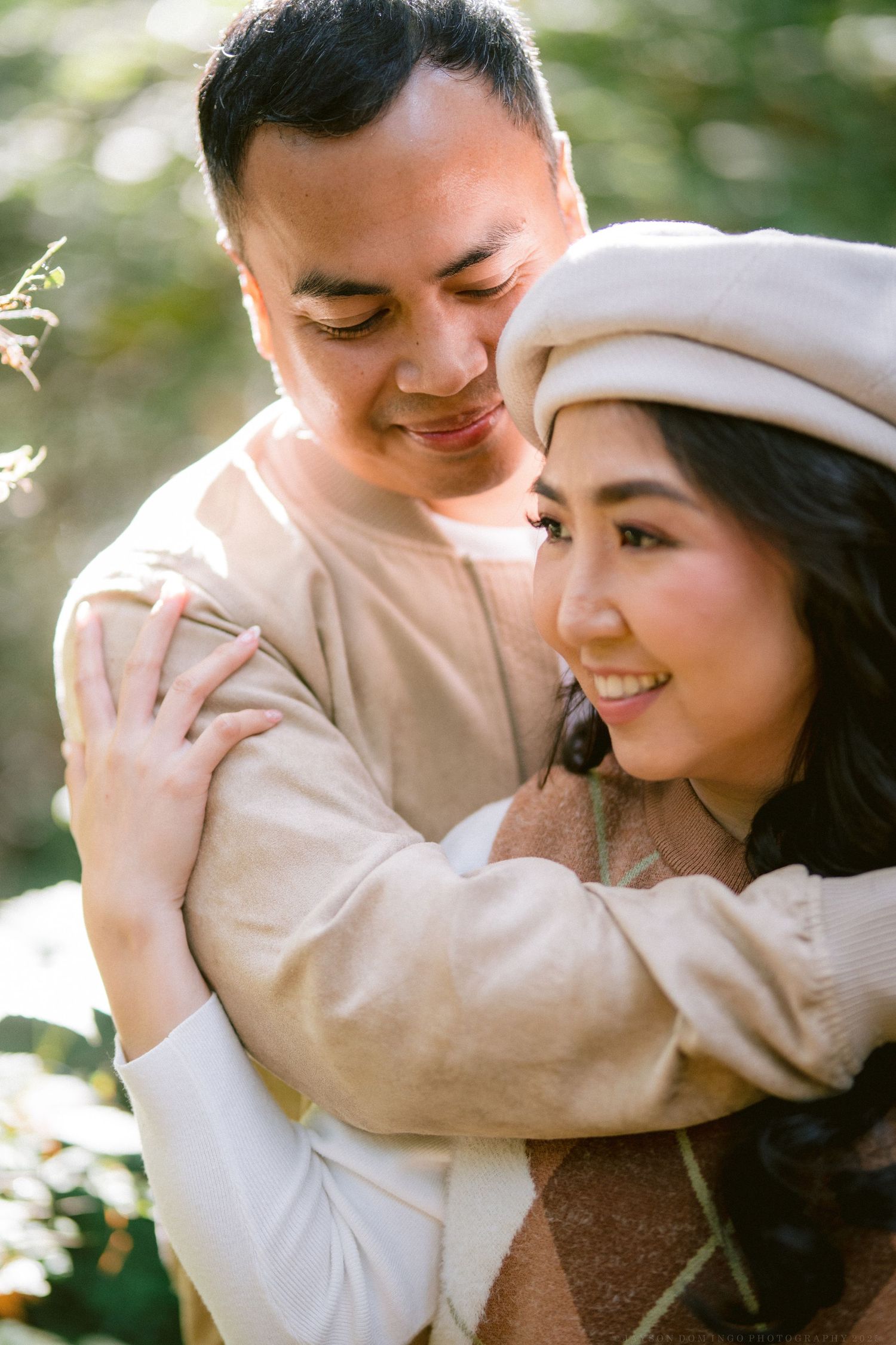 Intimate portrait of couple in beige outfits sharing a tender moment.